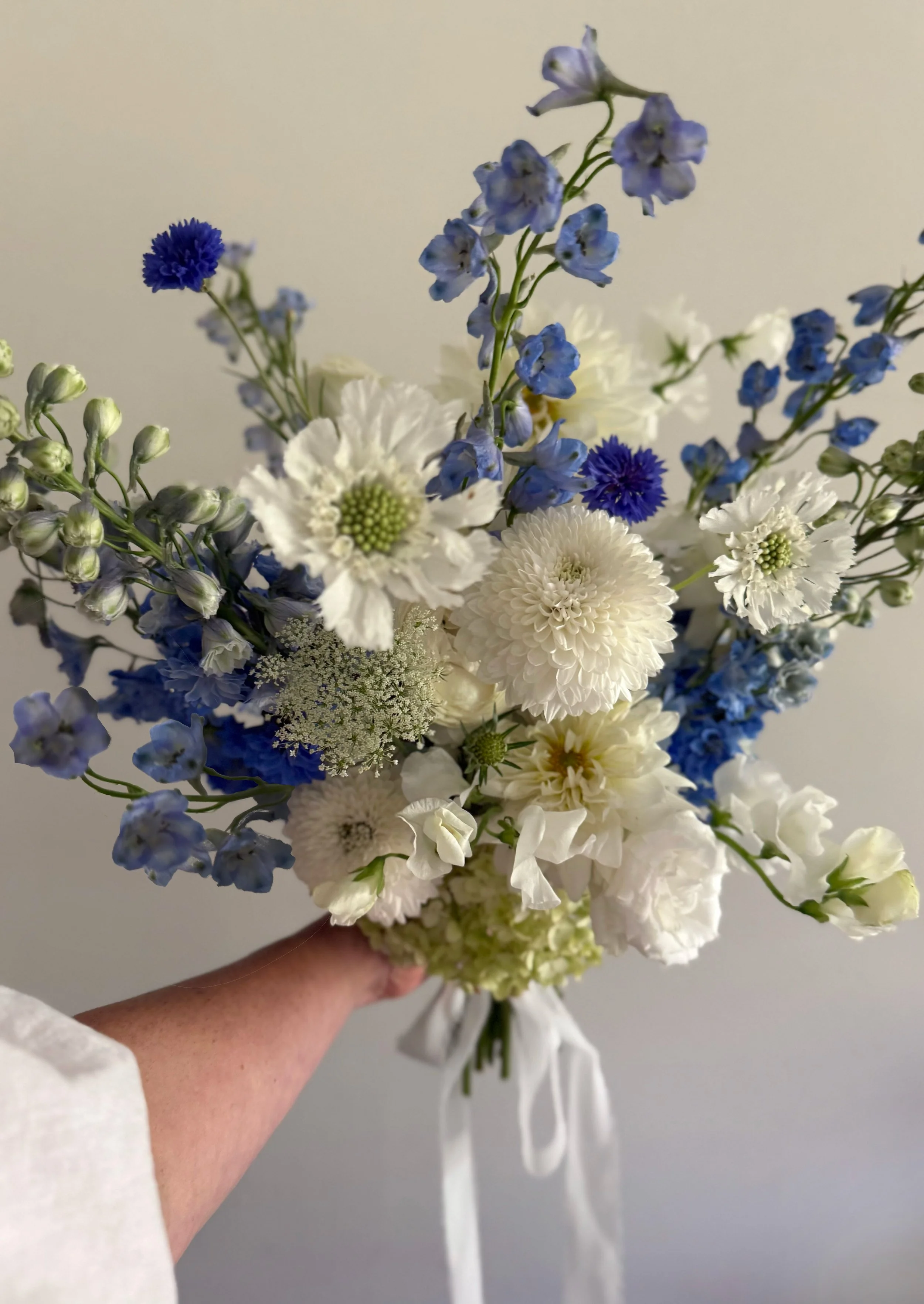 Minneapolis wedding bouquet with whites, blues, greens, whites. Dahlias, scabiosa, delphinium, hydrangea, sweet peas, ranunculus