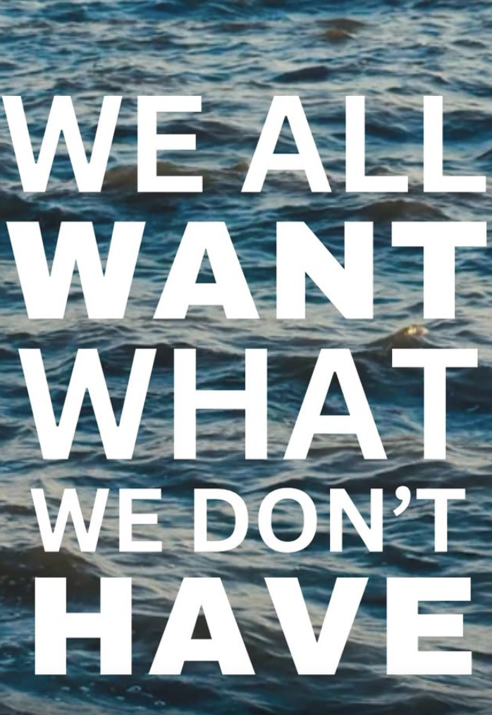 Text overlay on a photo of ocean water, reading 'We all want what we don't have'.