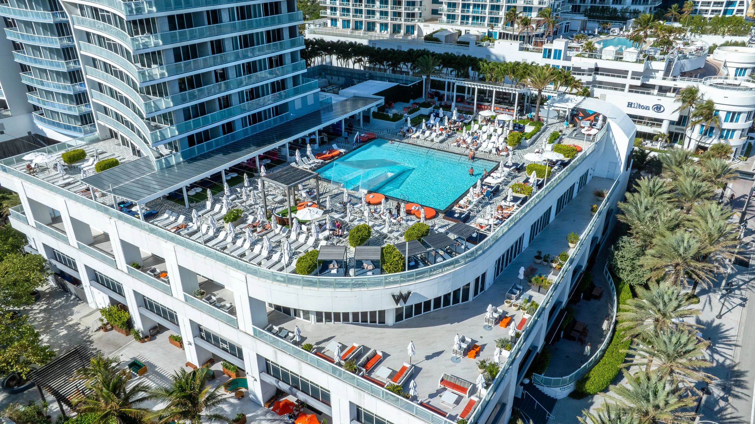 Aerial drone photograph of a South Florida resort pool deck and beachfront facade