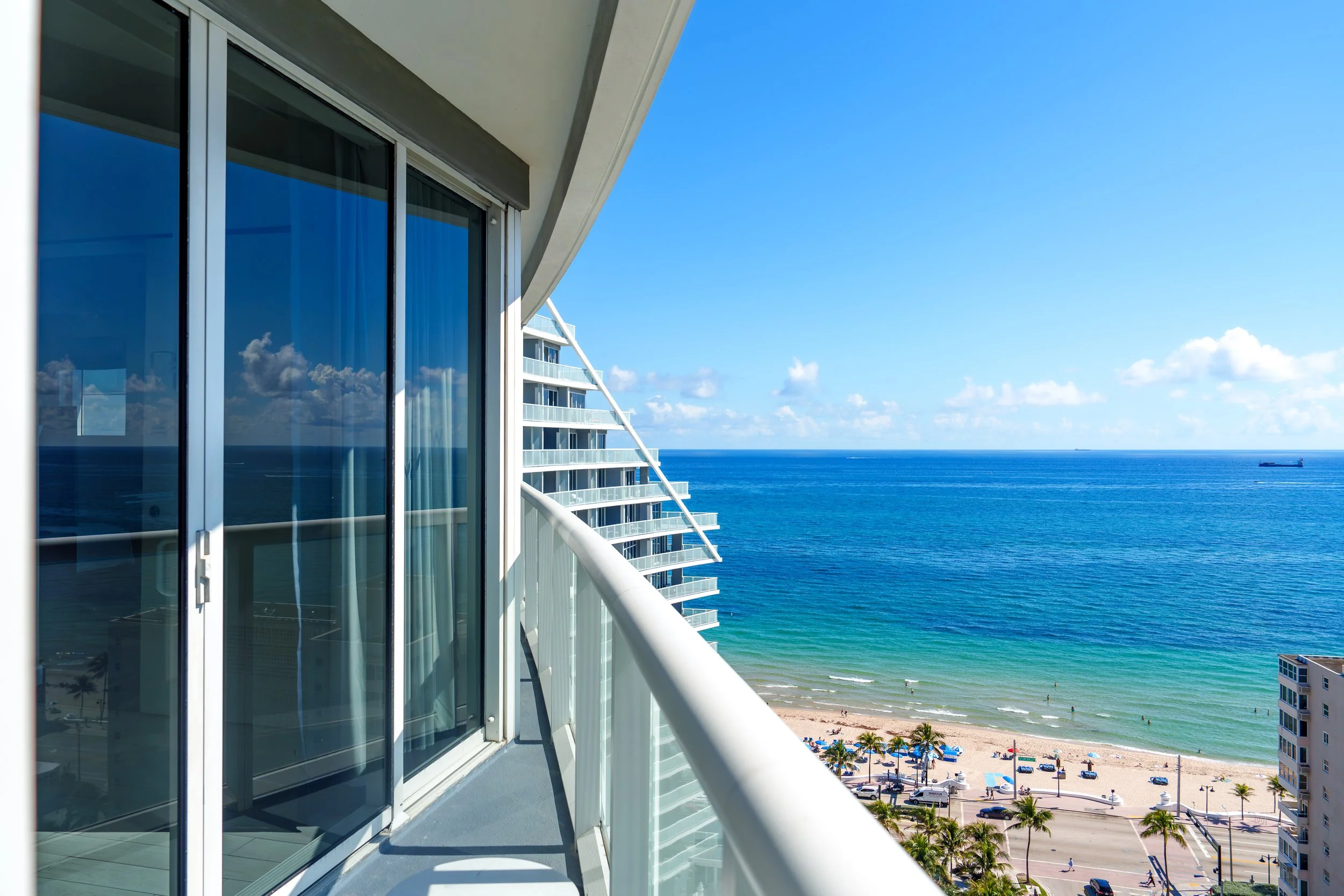 Hotel guest room balcony view of the ocean and palm trees in South Florida