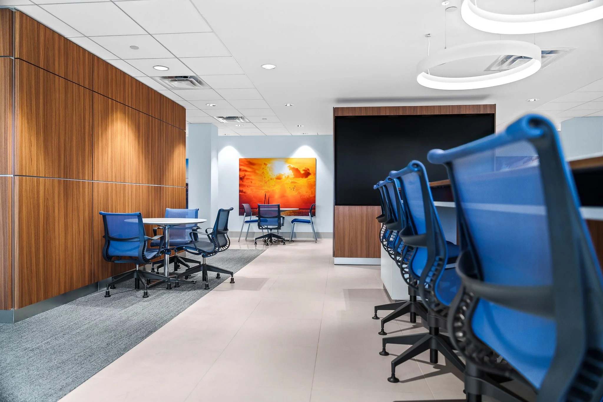Corporate boardroom interior with blue chairs and warm wood paneling staged for a commercial photography shoot