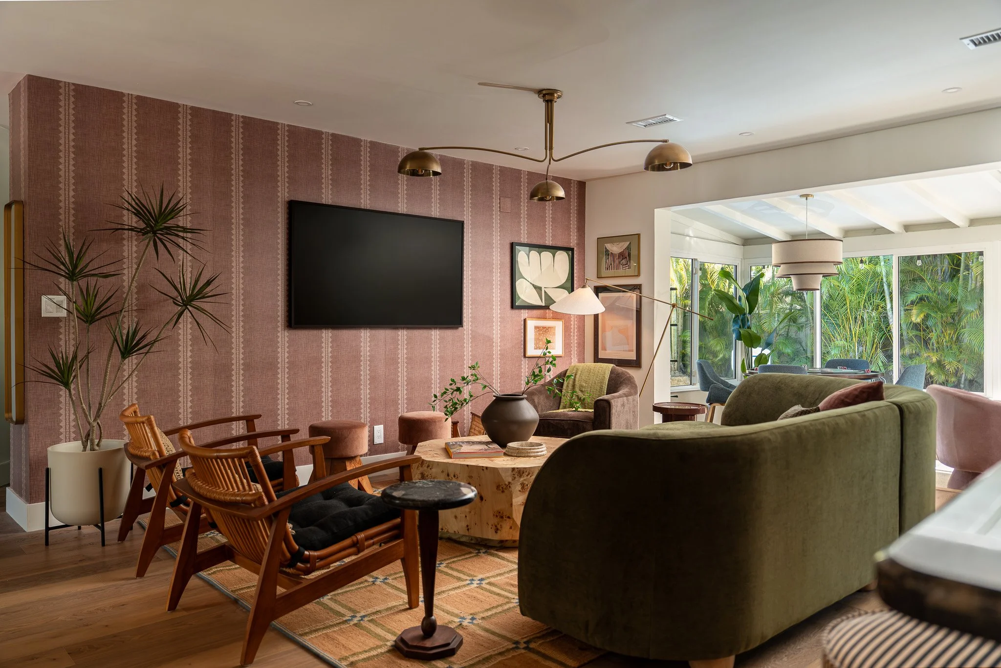 Modern living room interior with dusty rose accent wall, contemporary sofa, wood coffee table, and tropical plants - residential interior design photography in South Florida