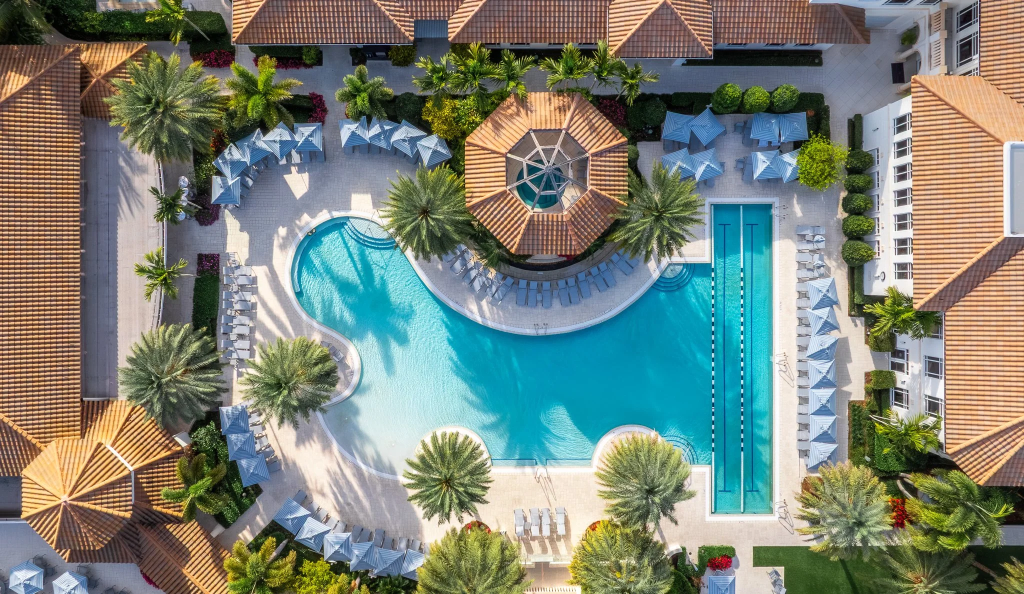 Aerial drone photography of a South Florida resort pool with palm trees and lounge chairs — hotel and hospitality photography by Fort Lauderdale photographer Adam J Tanner