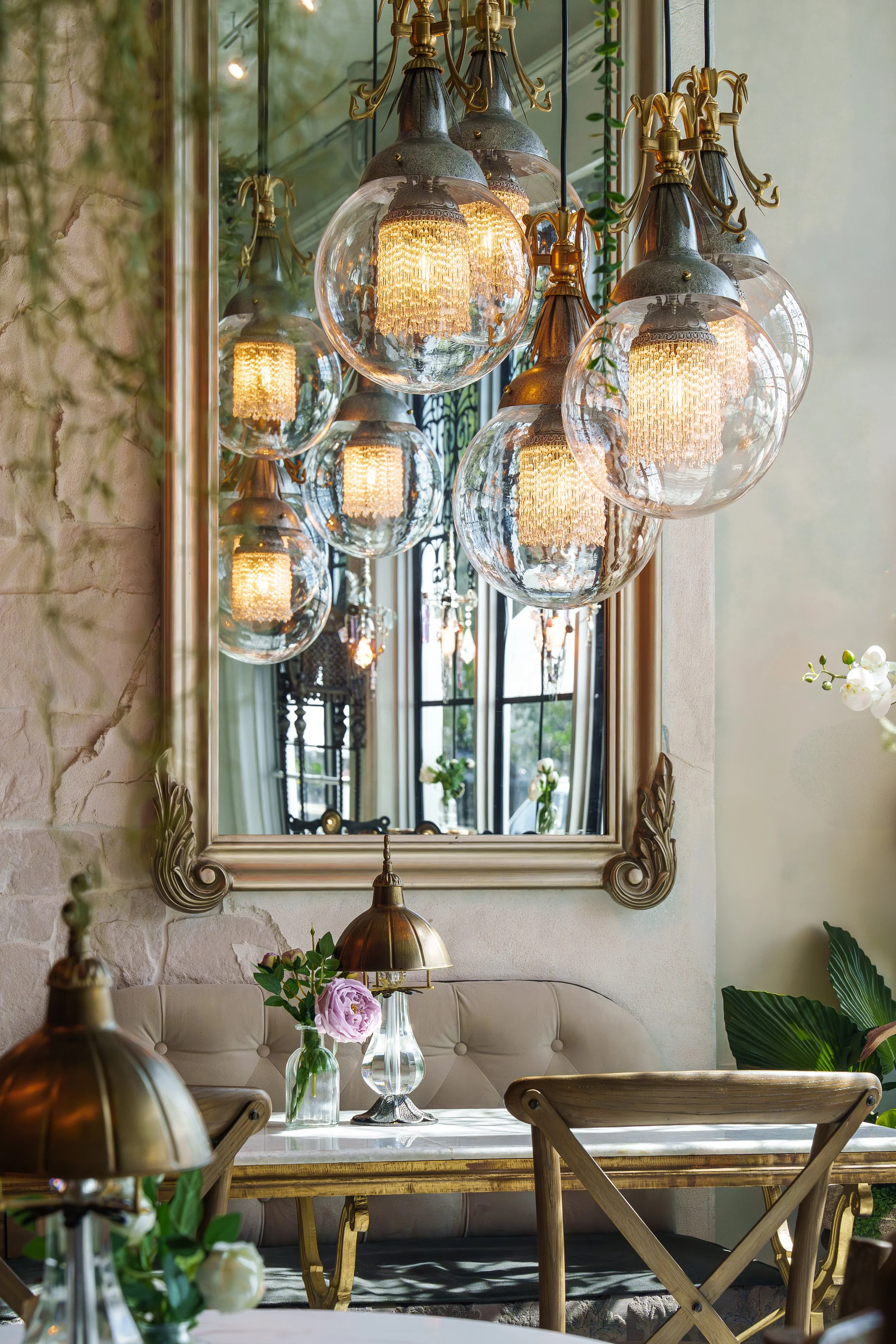 Detail interior photograph of glass globe chandeliers and decorative mirror in a boutique South Florida restaurant