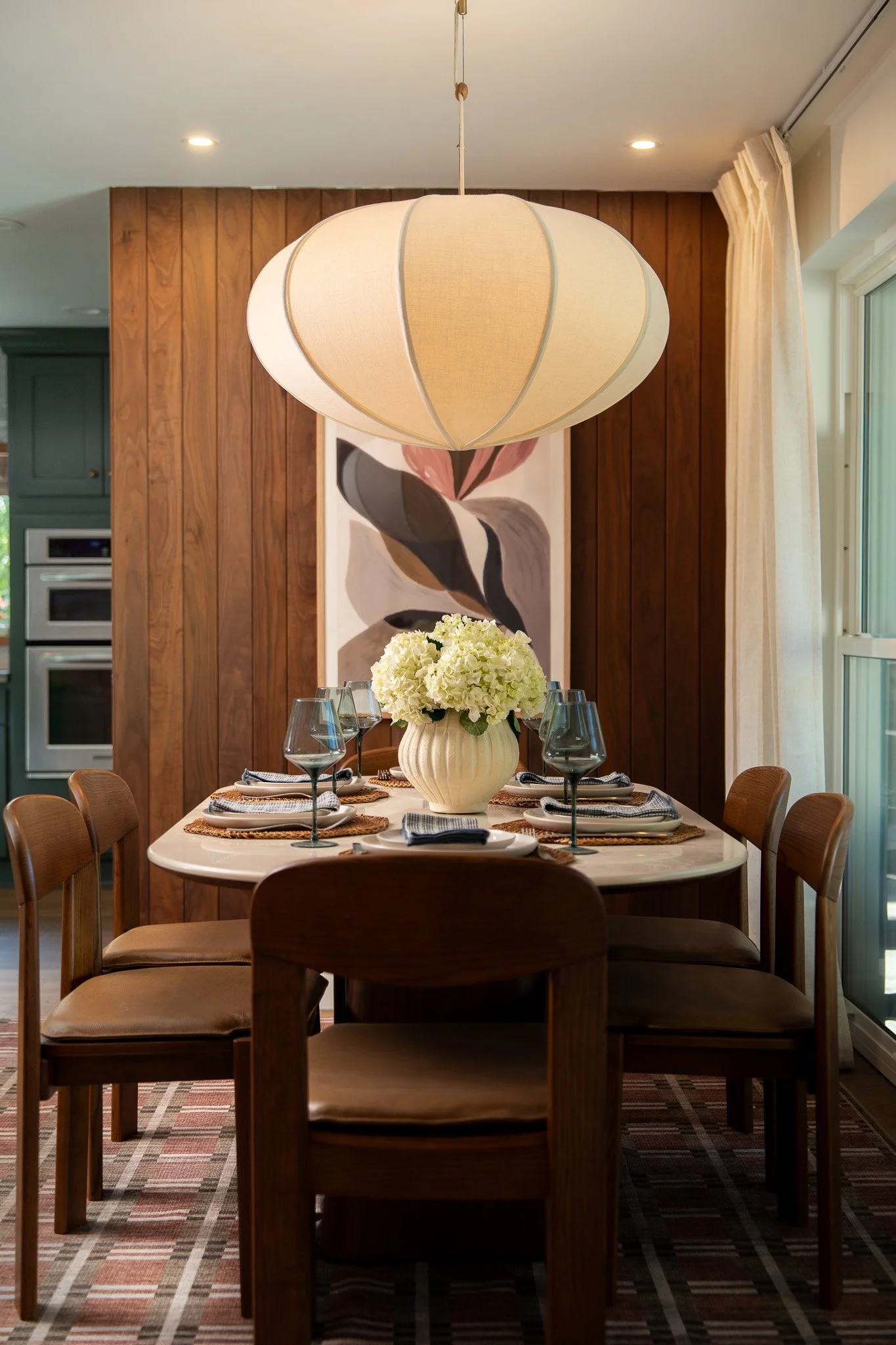 Elegant dining room interior with dark wood table, woven pendant light, and abstract artwork - luxury interior design photography by Fort Lauderdale photographer Adam J Tanner