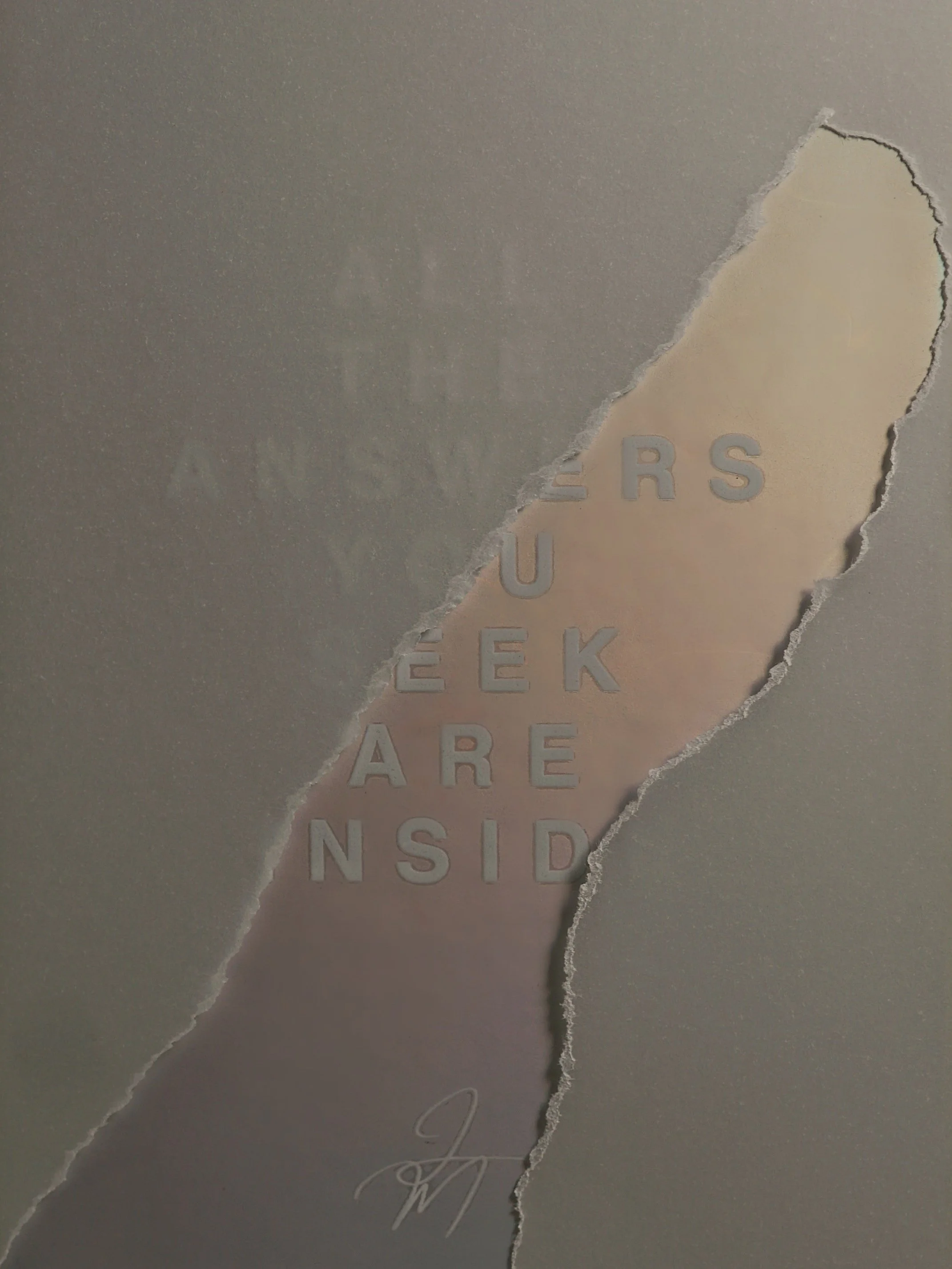 Torn paper revealing a quote written on the wall that says 'Sometimes we are inside' with a signature at the bottom.