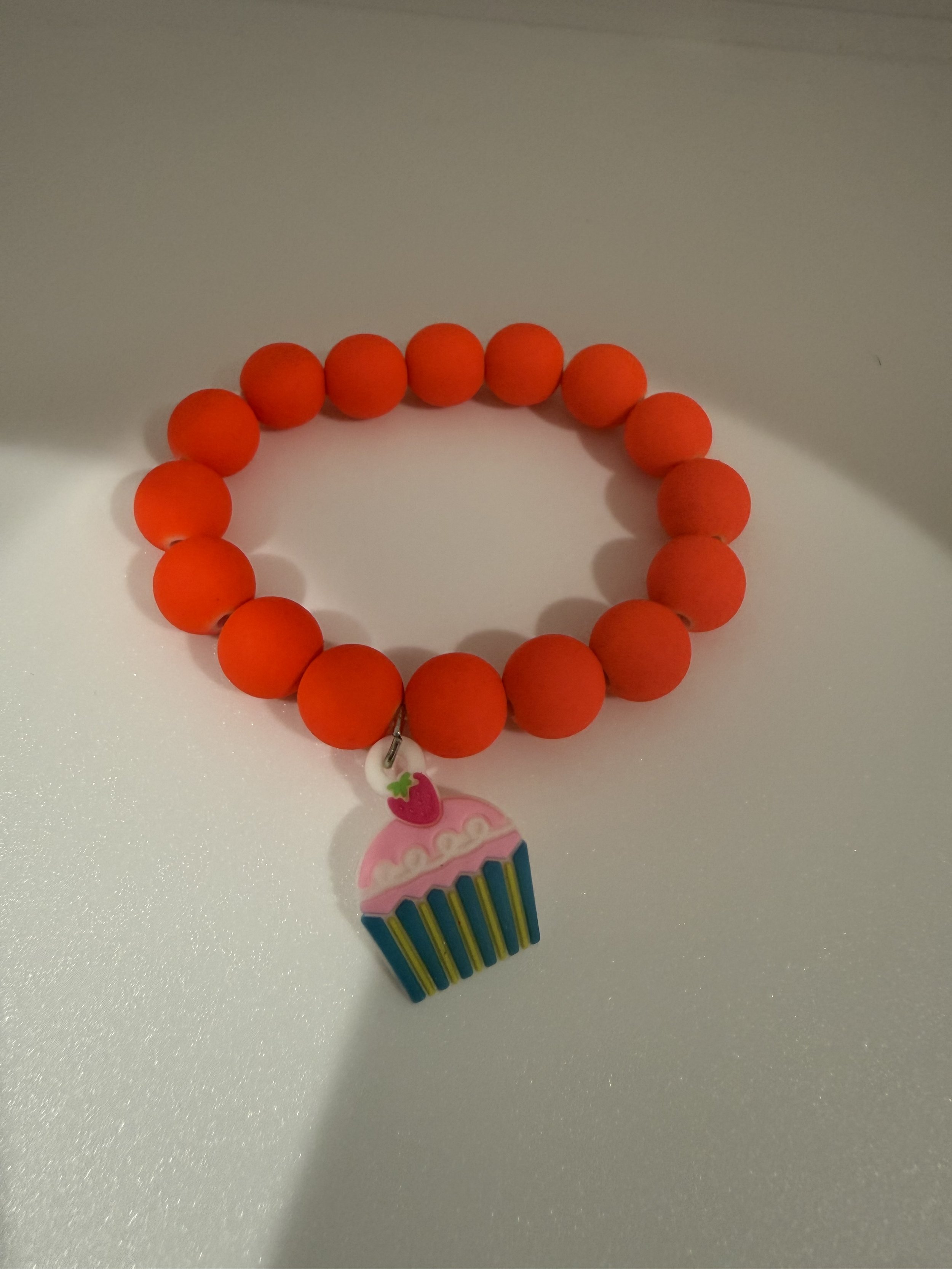 Orange beaded bracelet with cupcake charm