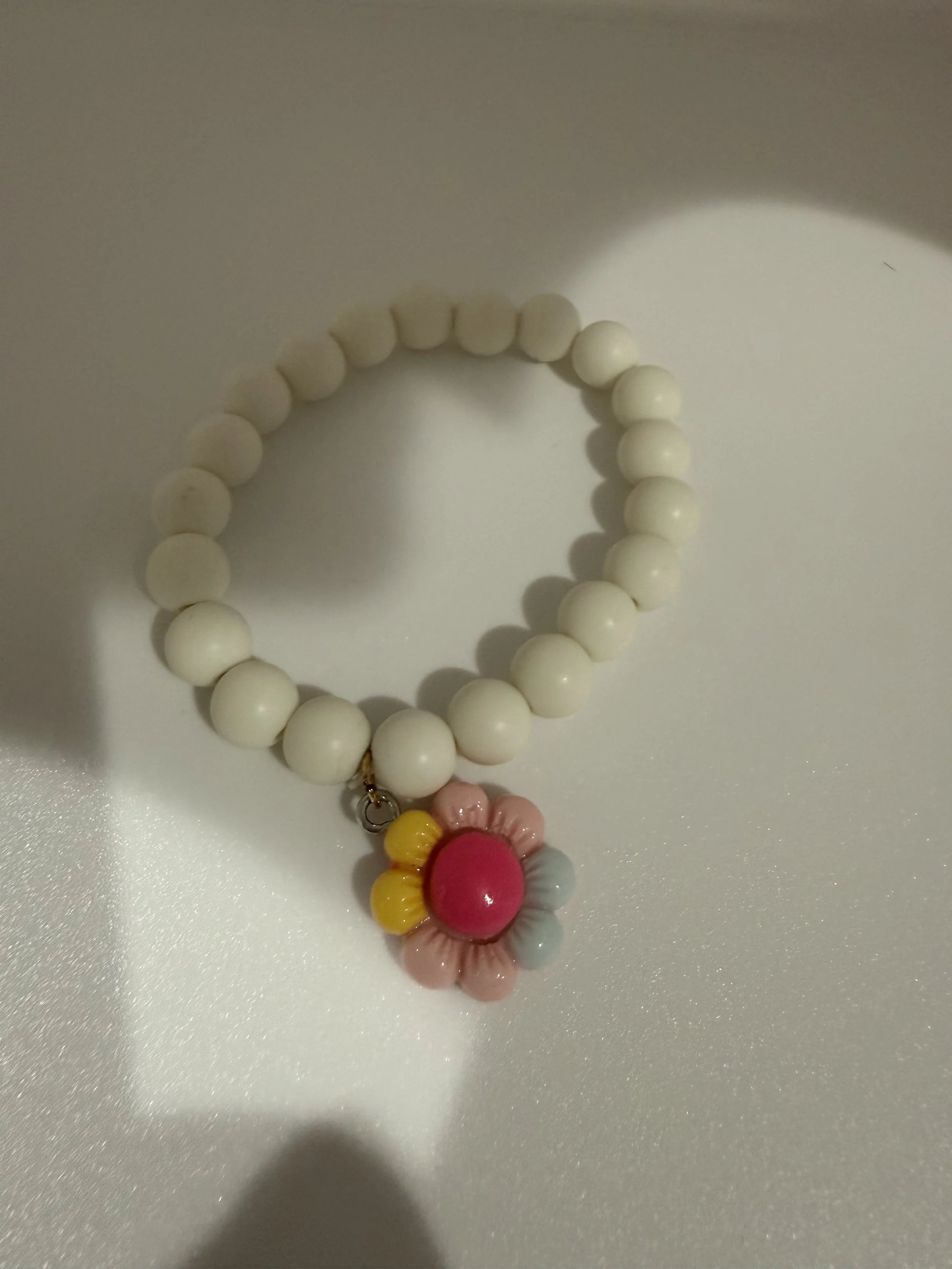 White beaded bracelet with flower charm