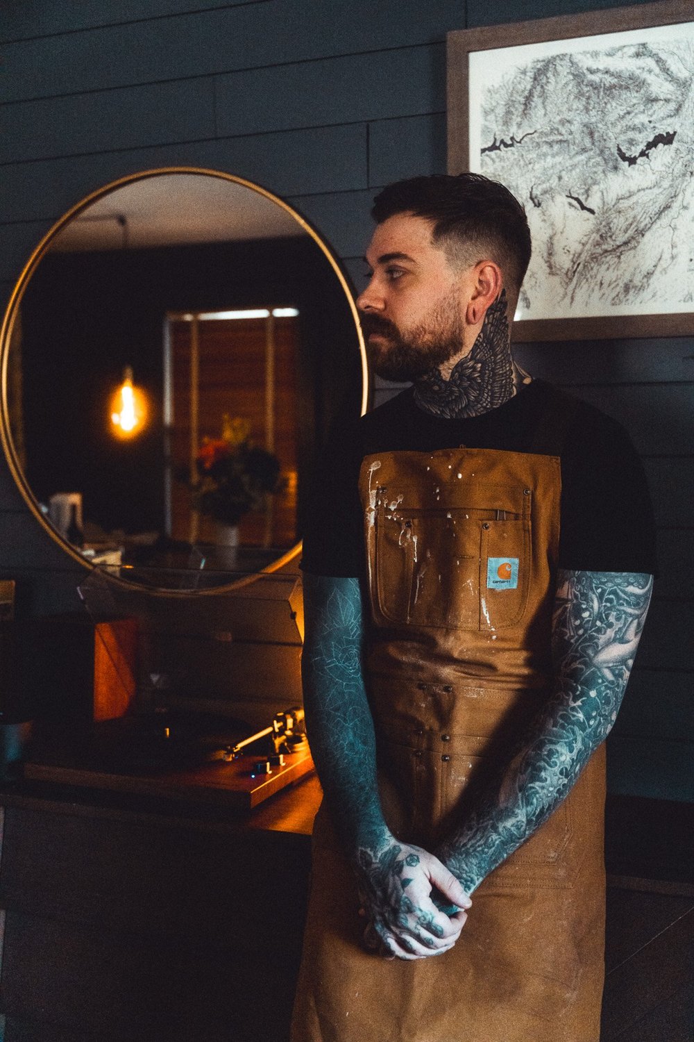 The maker of Stay North Supply Co. in his workshop, wearing a canvas work apron