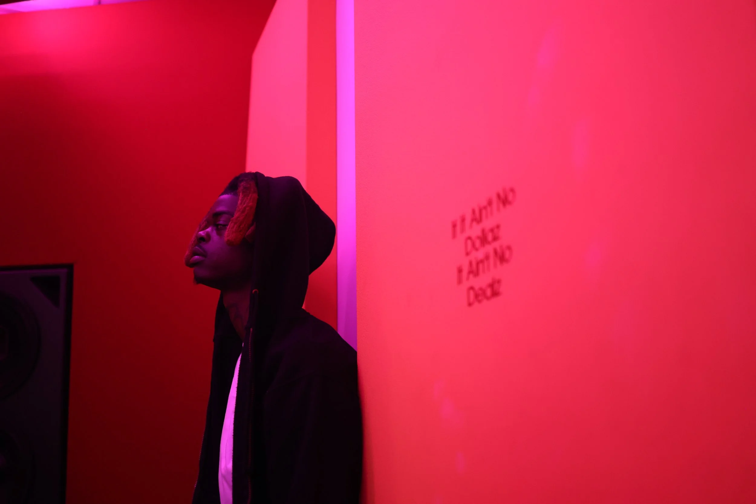Independent artist reflecting in a recording studio during an immersive creative camp, captured in a moody red-lit environment focused on growth and artistic clarity.