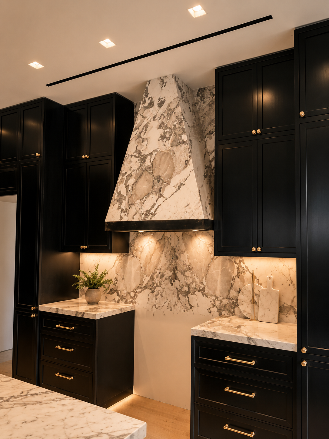Custom marble range hood surround with full-height marble backsplash and matching kitchen countertops.