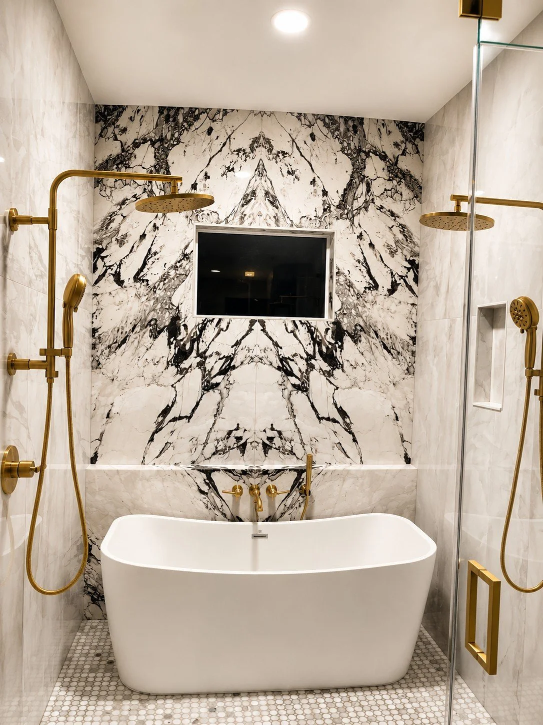 Luxury marble bathroom featuring a bookmatched stone accent wall, freestanding tub, and custom stone fabrication.