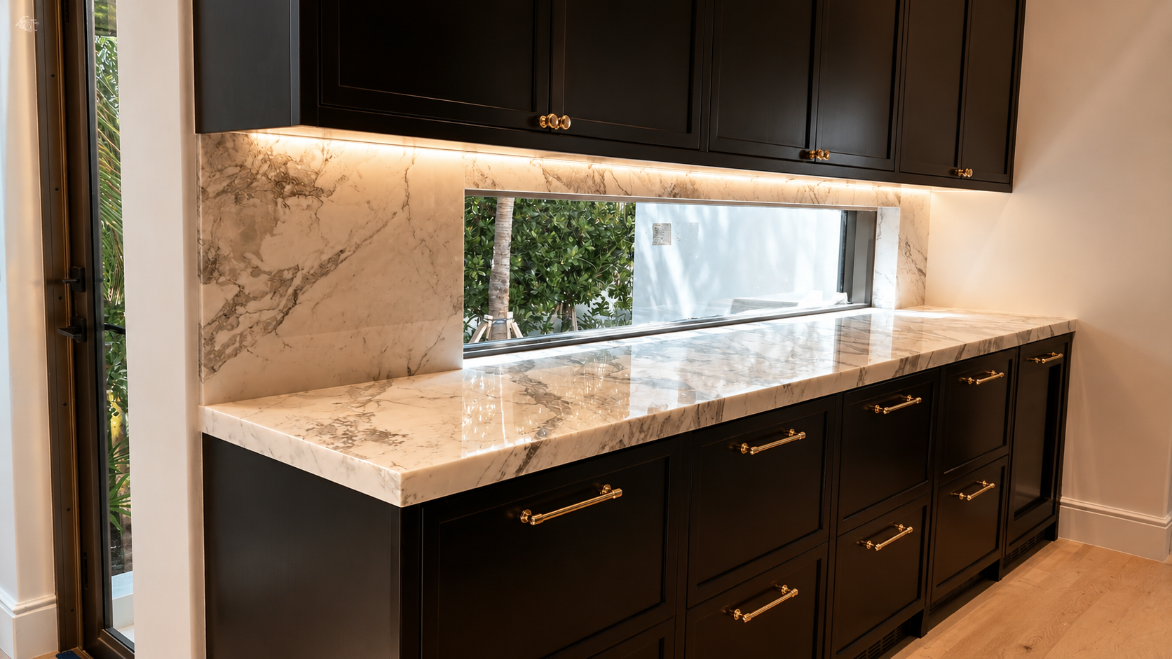 Custom marble kitchen countertops with a full-height backsplash and seamless window sill detail.