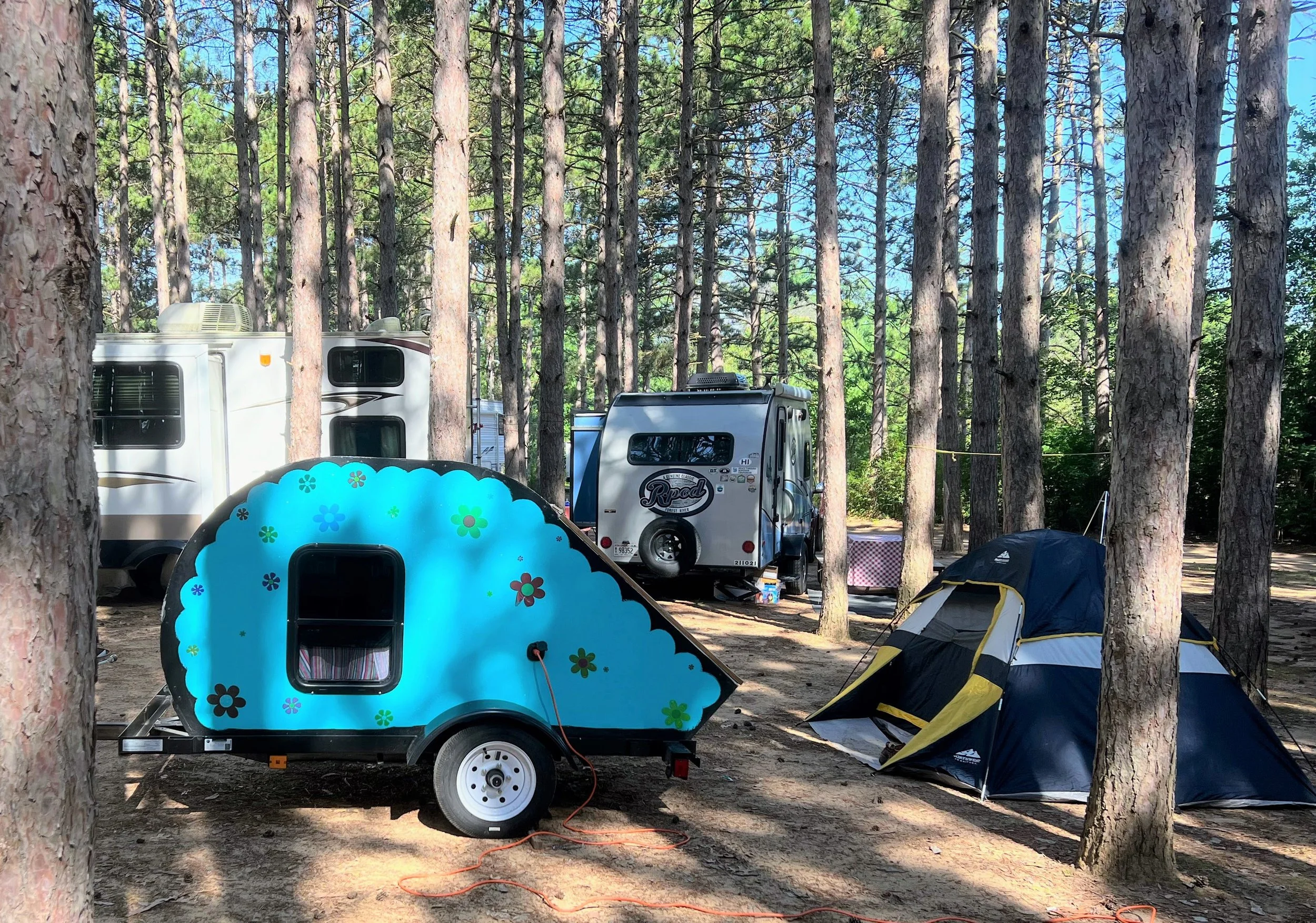 cute teal teardrop camper in pines at Dell Pines Campground near Wisconsin Dells 
