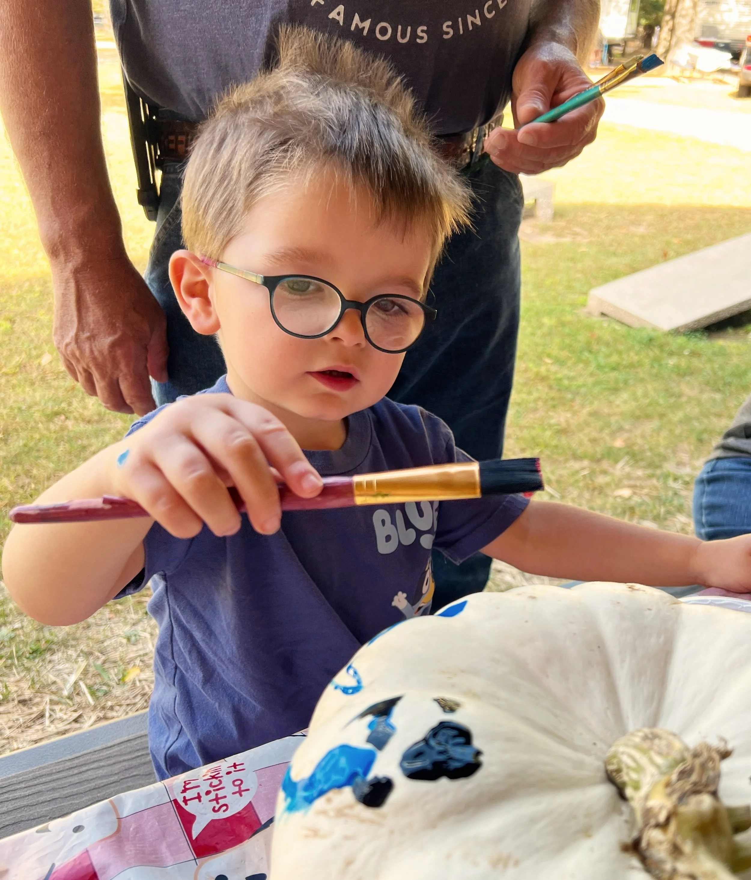 young boy paining a pumpkin Halloween at the Campground at Dell Pines Campground
