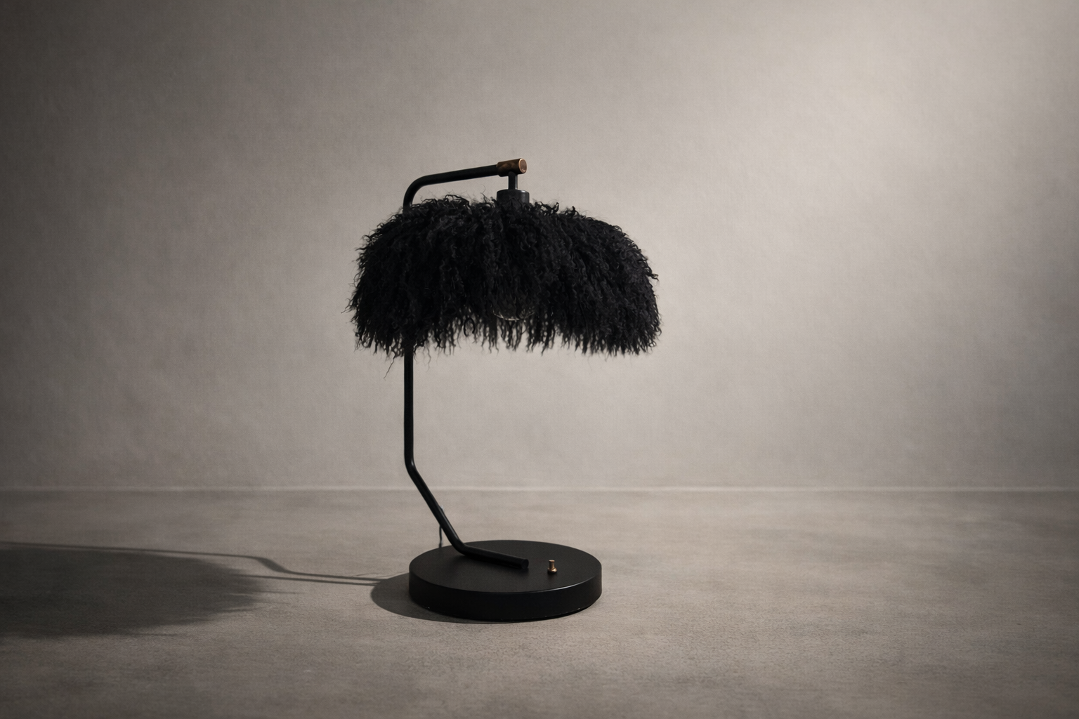 Black Mongolian lamb table lamp with glass inner shade and matte black metal base, photographed in a minimal studio setting