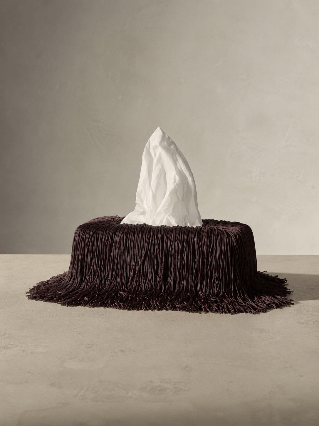 Bordeaux Noir fringe tissue box cover featuring cascading burgundy fringe draped over an elongated rectangular silhouette, creating a sculptural statement piece for luxury interiors and powder rooms.