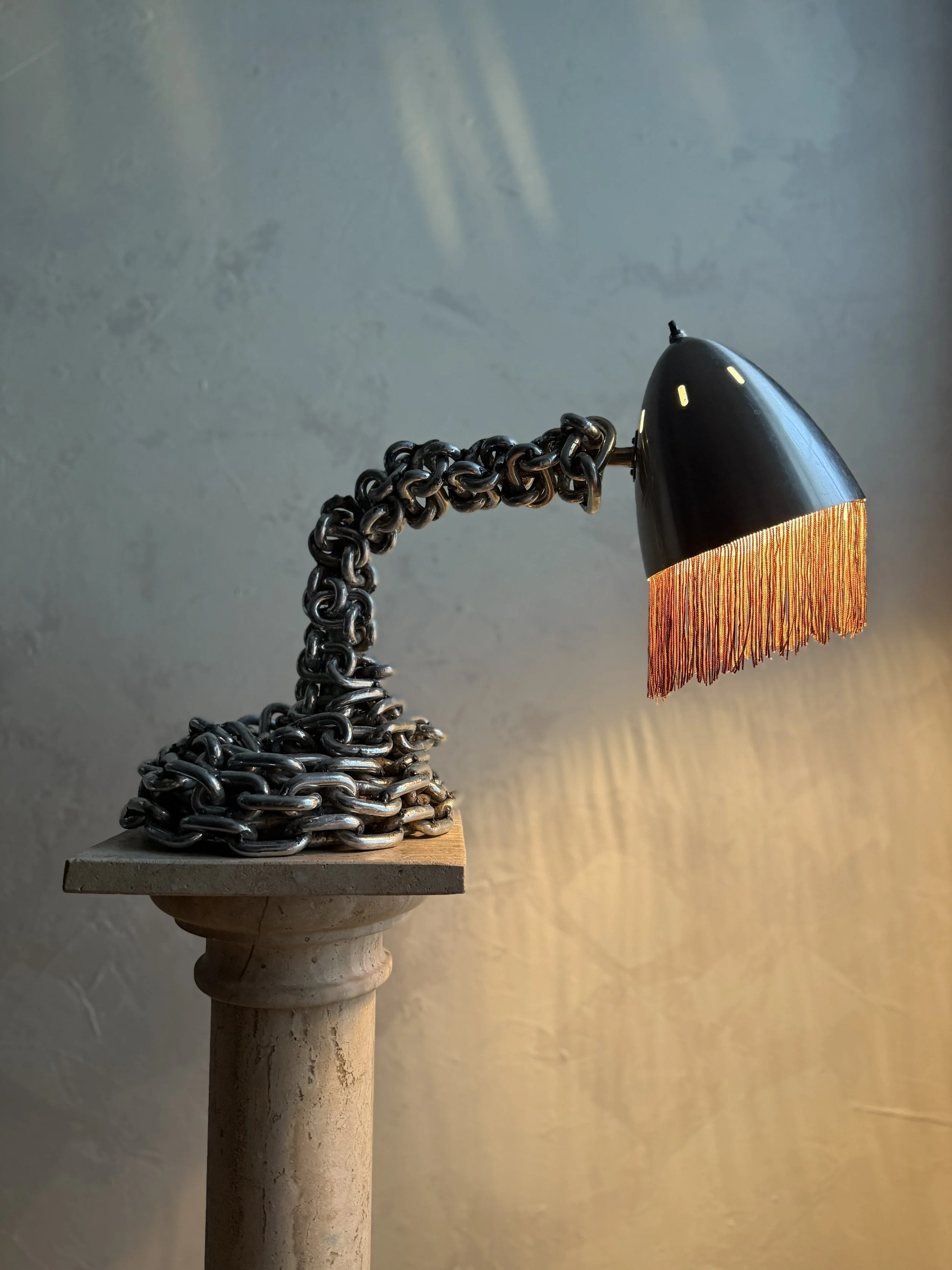 Chain table lamp with fringe shade in warm, textural glow