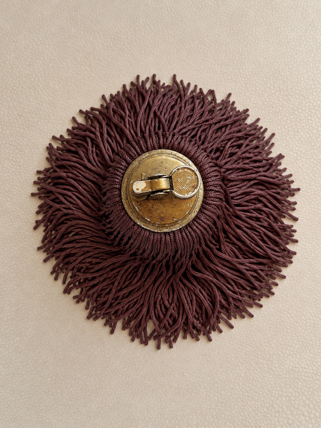 Overhead view of a vintage onyx table lighter surrounded by cascading Bordeaux Noir fringe, a one-of-a-kind decorative object by Amber Renee Hansen.