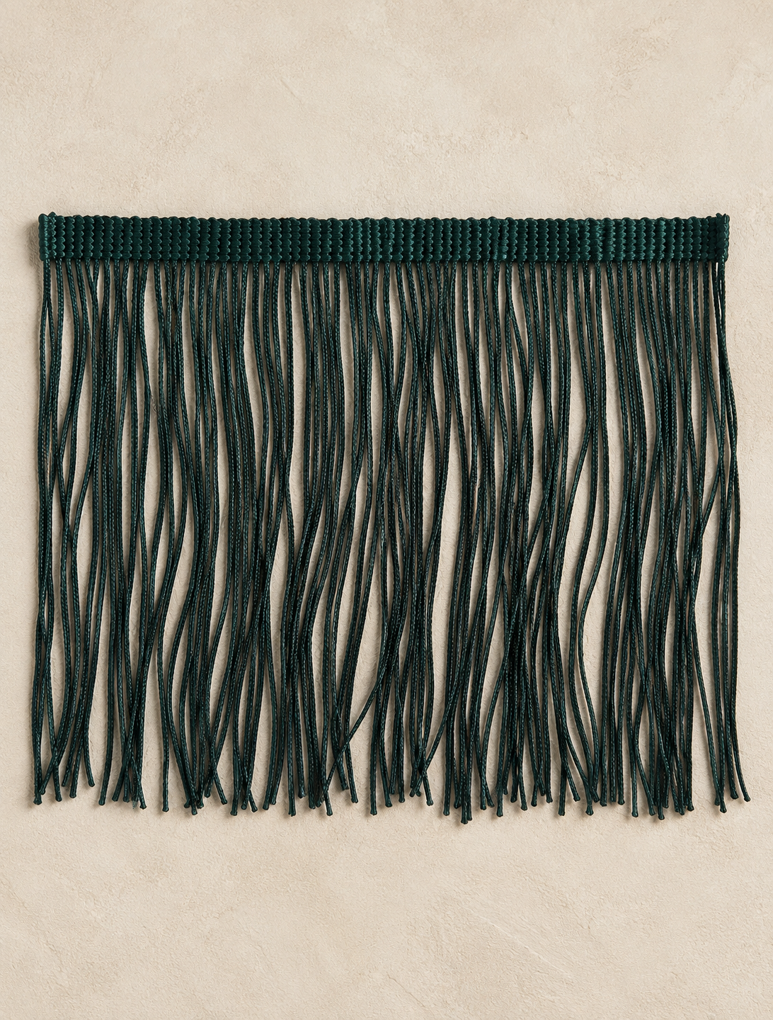 Detailed view of dense dark forest green fringe on the Forest Noir Spill Edit tissue box cover by Amber Renee Hansen.