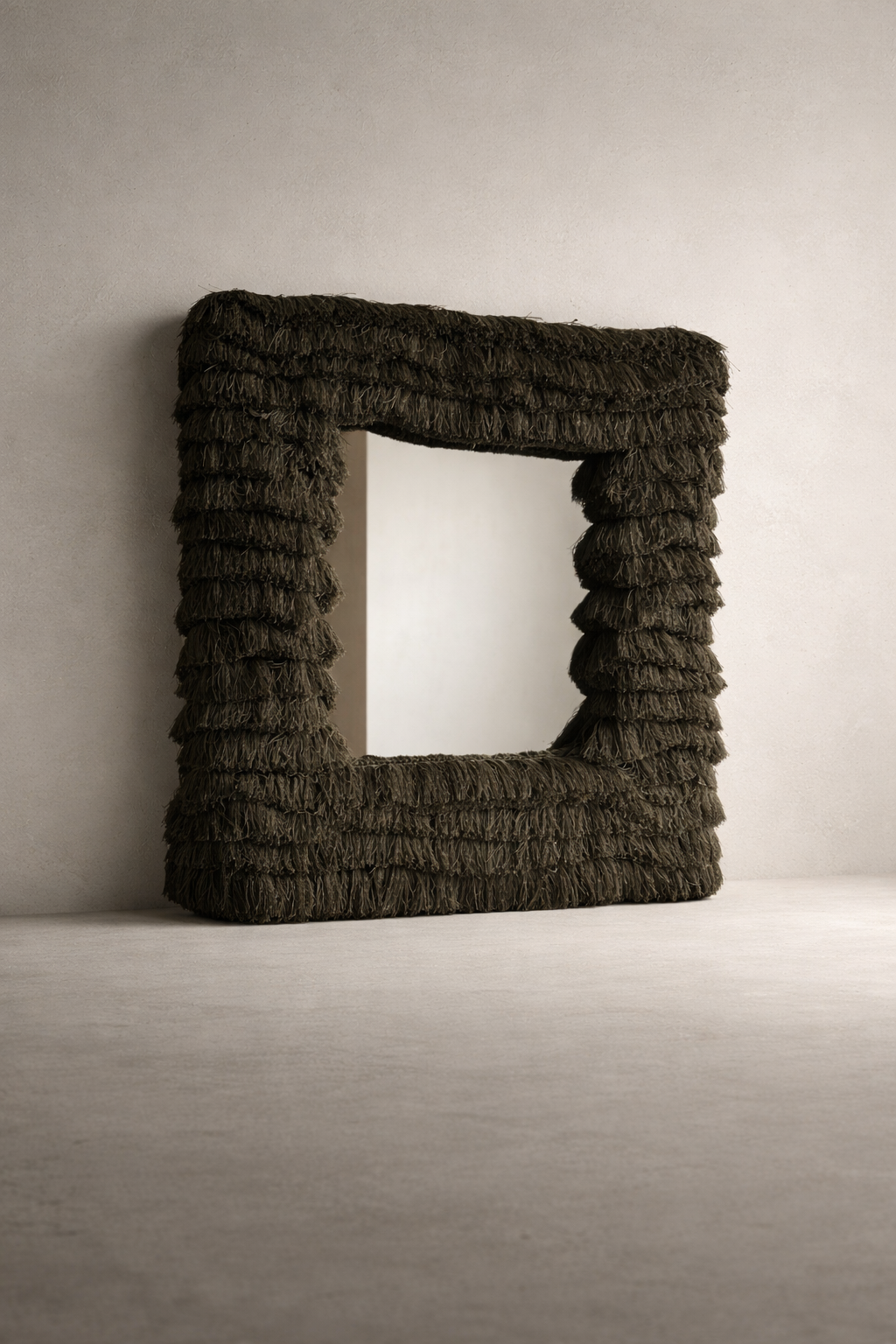 Layered olive fringe square wall mirror with sculptural texture photographed in a neutral studio setting