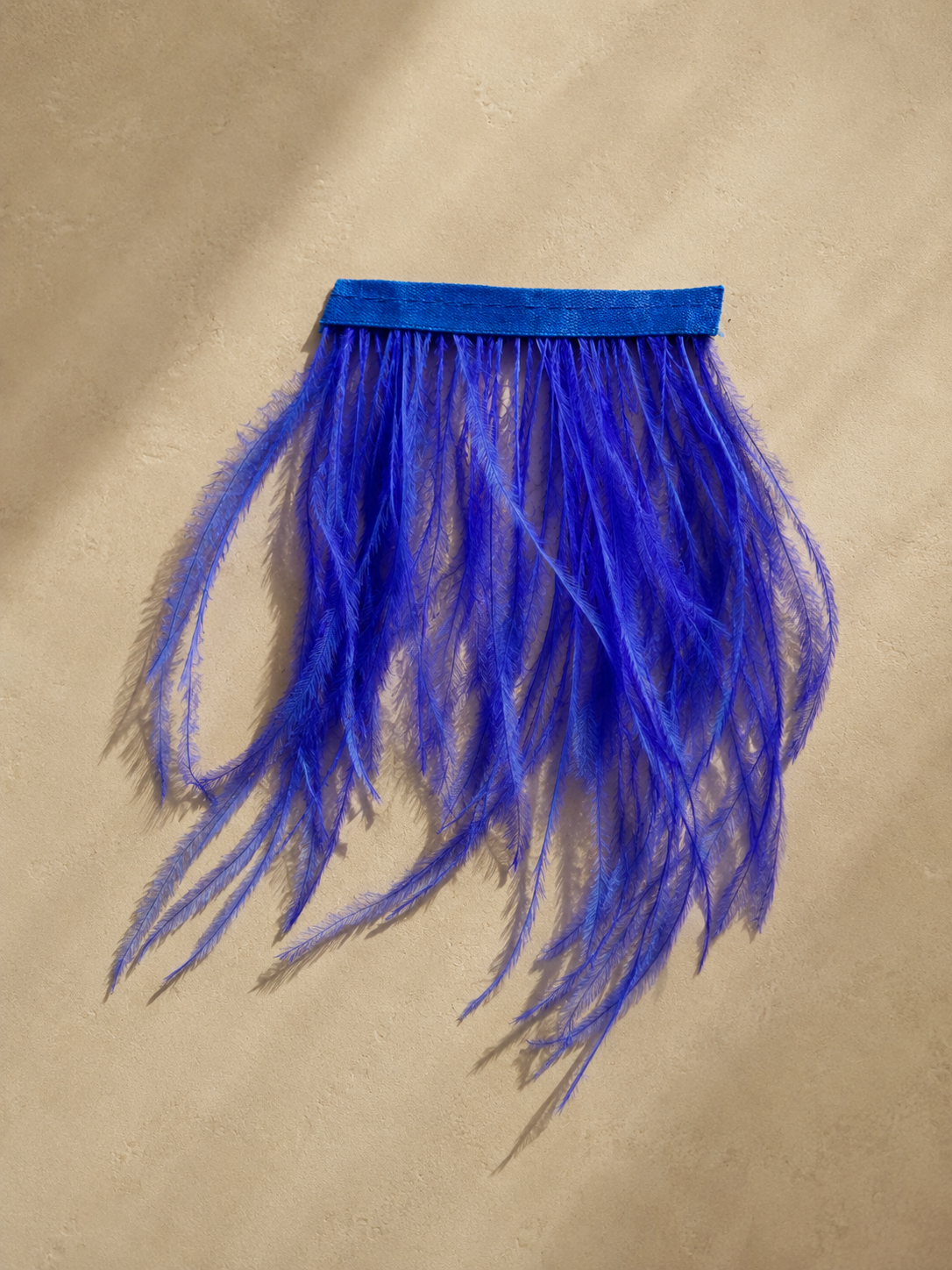 Detail of vivid ultramarine blue ostrich feathers used on a sculptural tissue box cover by Amber Renee Hansen.