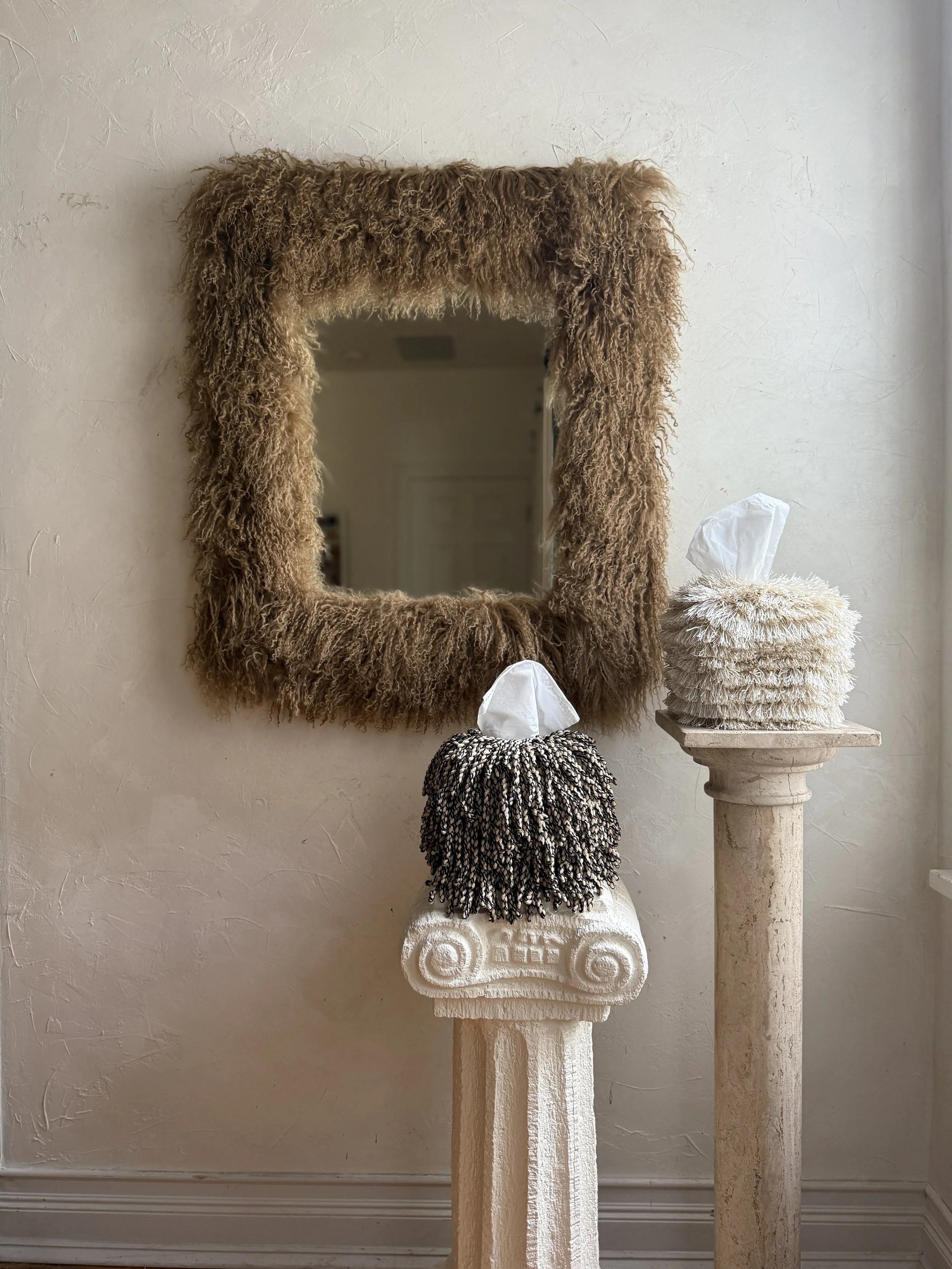Mongolian lamb sheepskin mirror in Miso — a warm, textural beige tone styled against a plaster wall with soft natural light.