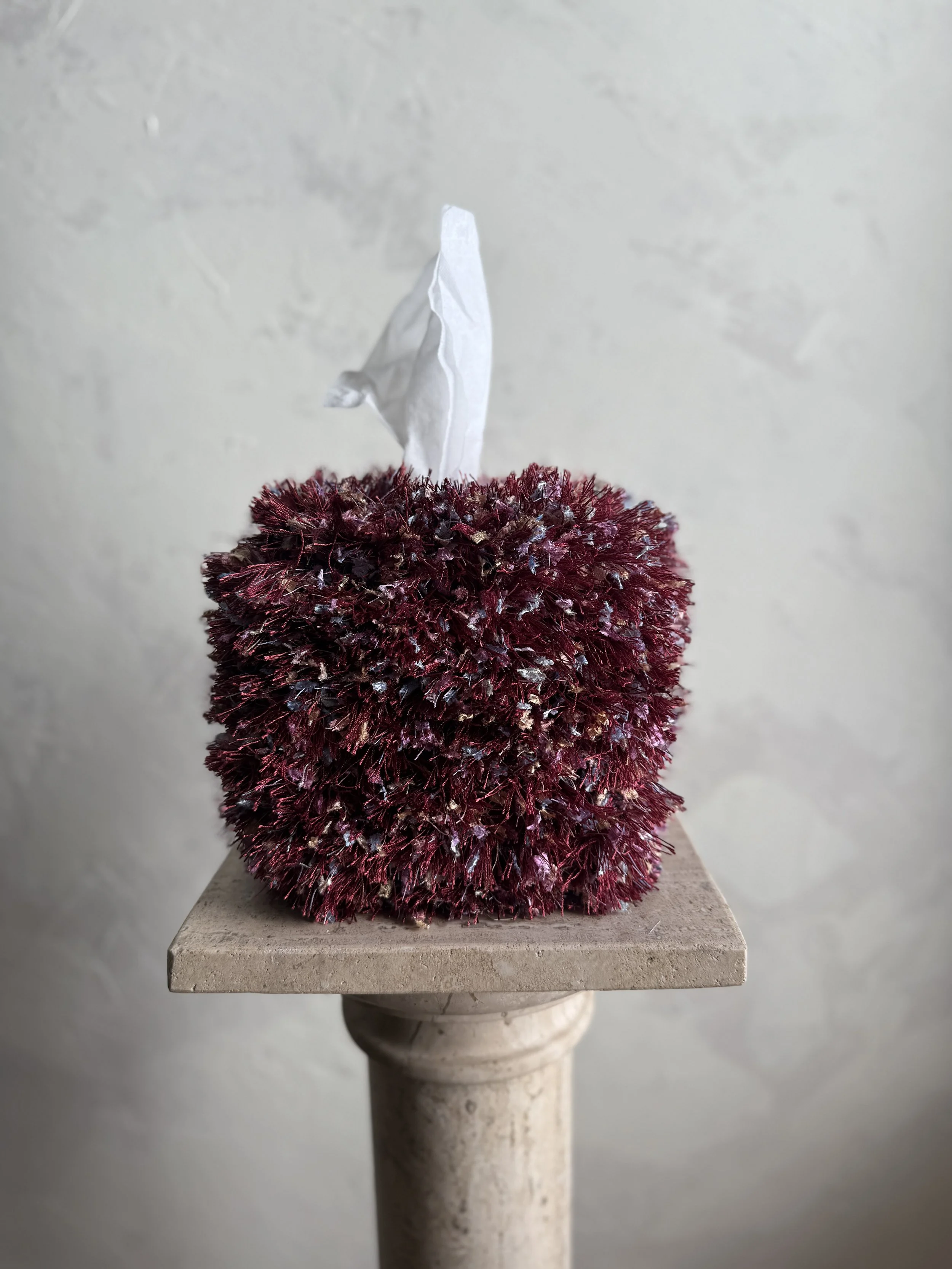 Funfetti Fringe Tissue Box Cover by Amber Renee Hansen, multicolored fringe design with playful confetti-inspired texture, styled in a Wabi-Sabi plaster setting.