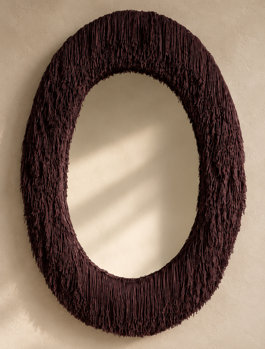 Close-up of a custom Bordeaux fringe mirror by Amber Renee Hansen, featuring layered textile fringe and a sculptural draped frame for a designer powder room.
