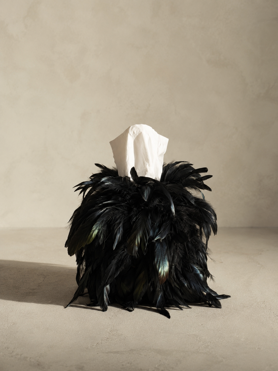 Midnight Feather Tissue Box Cover wrapped in genuine black feathers with subtle iridescent sheen.