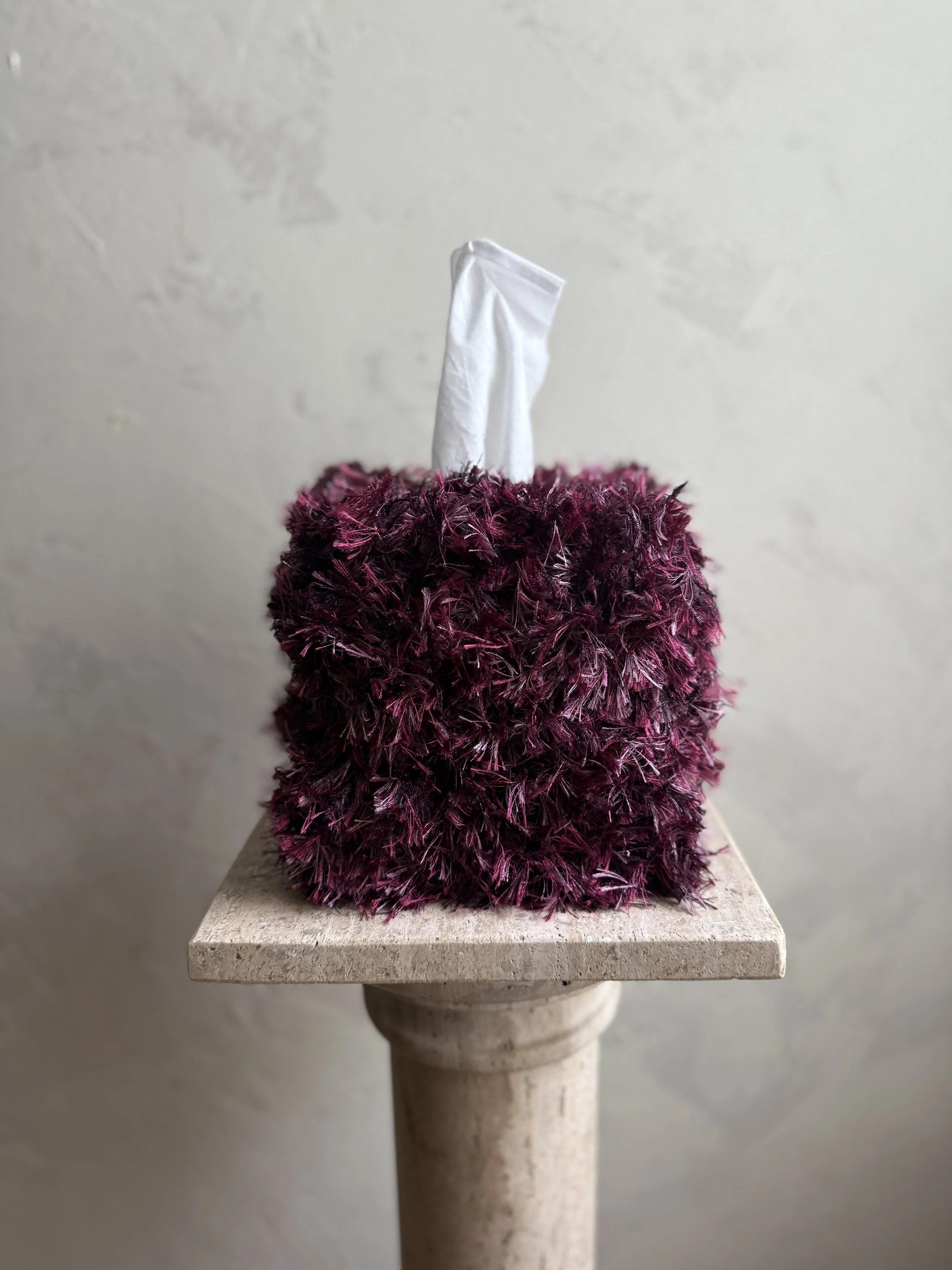 Close-up of the Mulberry Teddy tissue box cover, wrapped in plush fringe in layered mulberry, berry, and plum tones, adding soft texture and sculptural warmth.