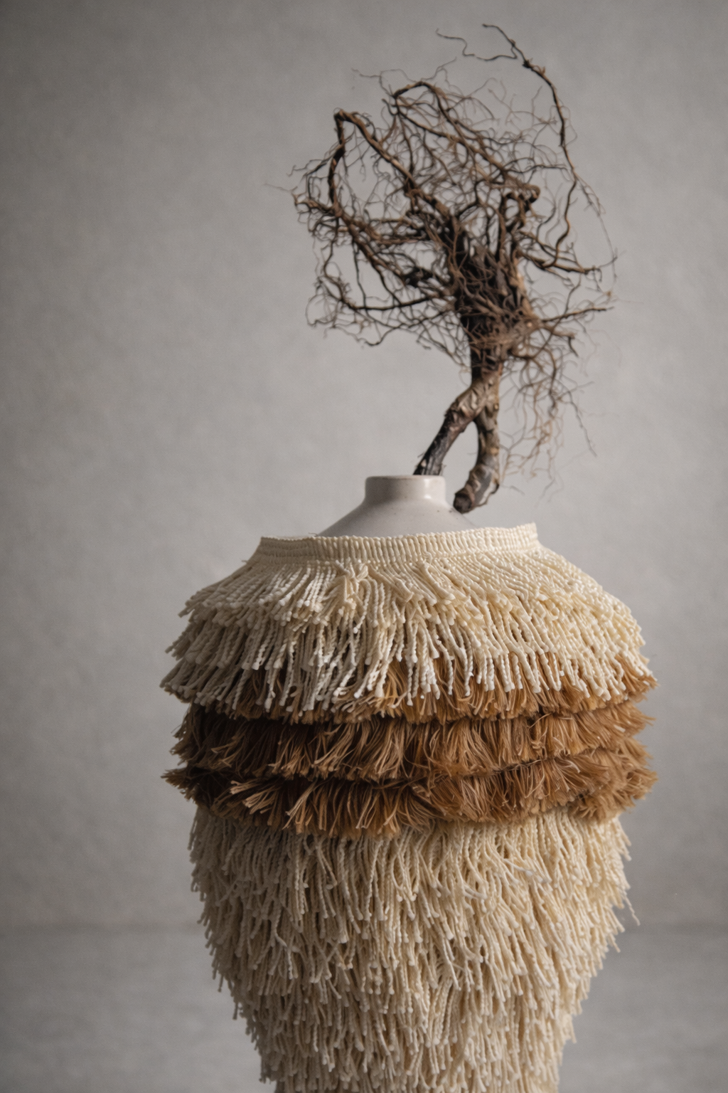 Tiered fringe vessel with layered neutral fringe and a box-root crown by Amber Renee Hansen