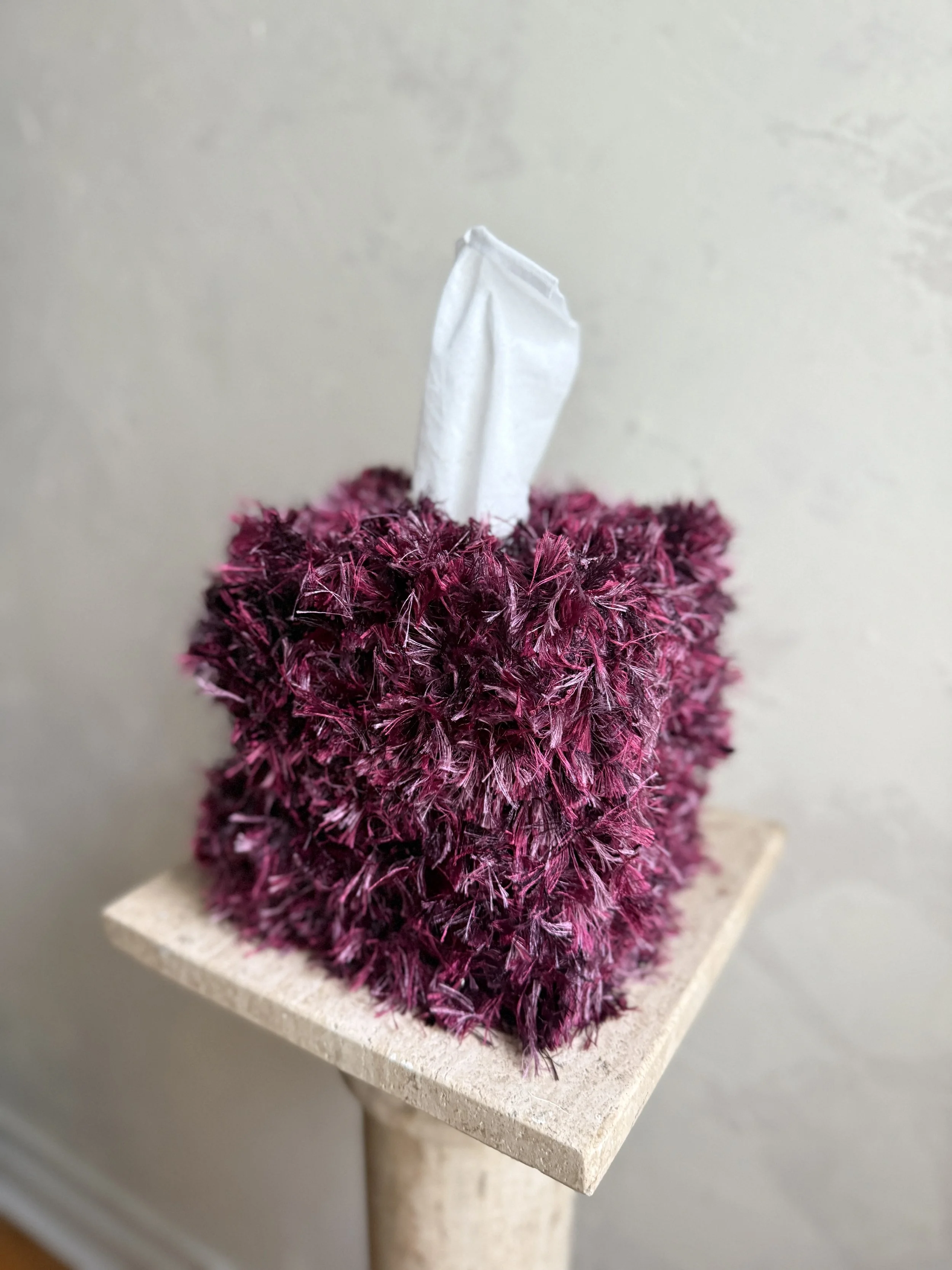 Close-up of the Mulberry Teddy tissue box cover, wrapped in plush fringe in layered mulberry, berry, and plum tones, adding soft texture and sculptural warmth.