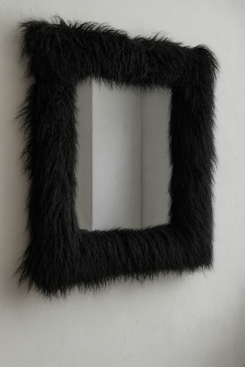 Black Mongolian lamb sheepskin sculptural mirror mounted on plaster wall, Axis mirror by Amber Renee Hansen