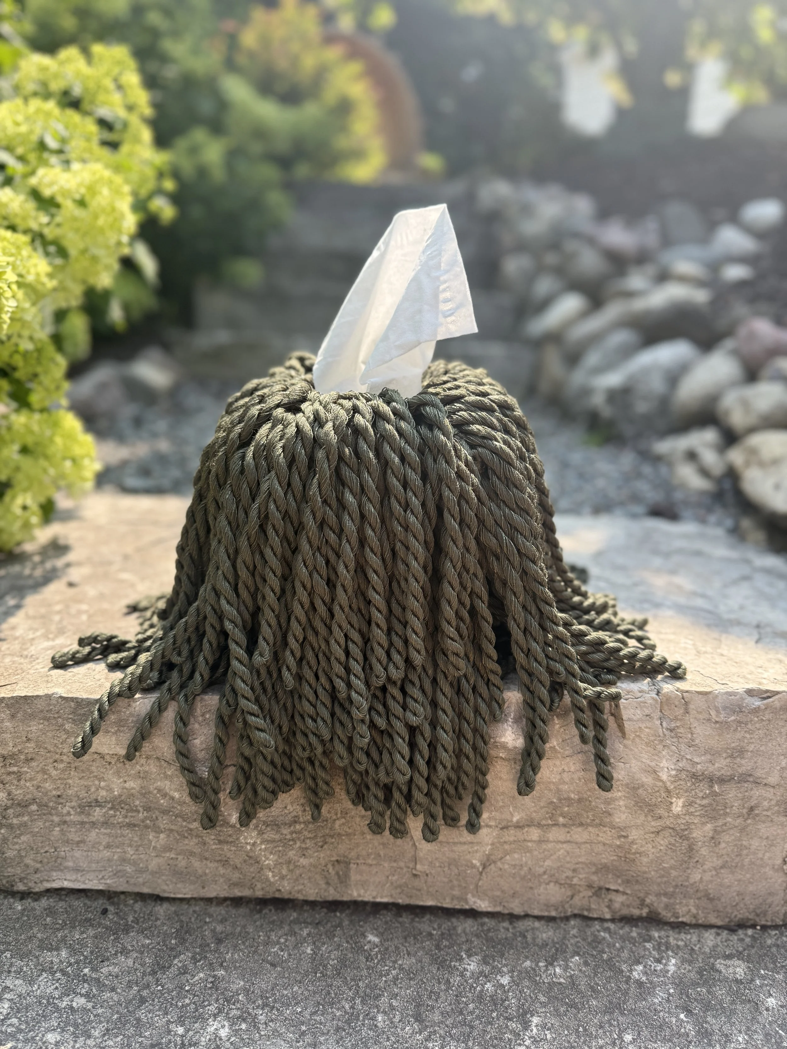 Forest Shadow fringe tissue box cover in dark moss green styled in a refined interior setting, oversized sculptural drape.