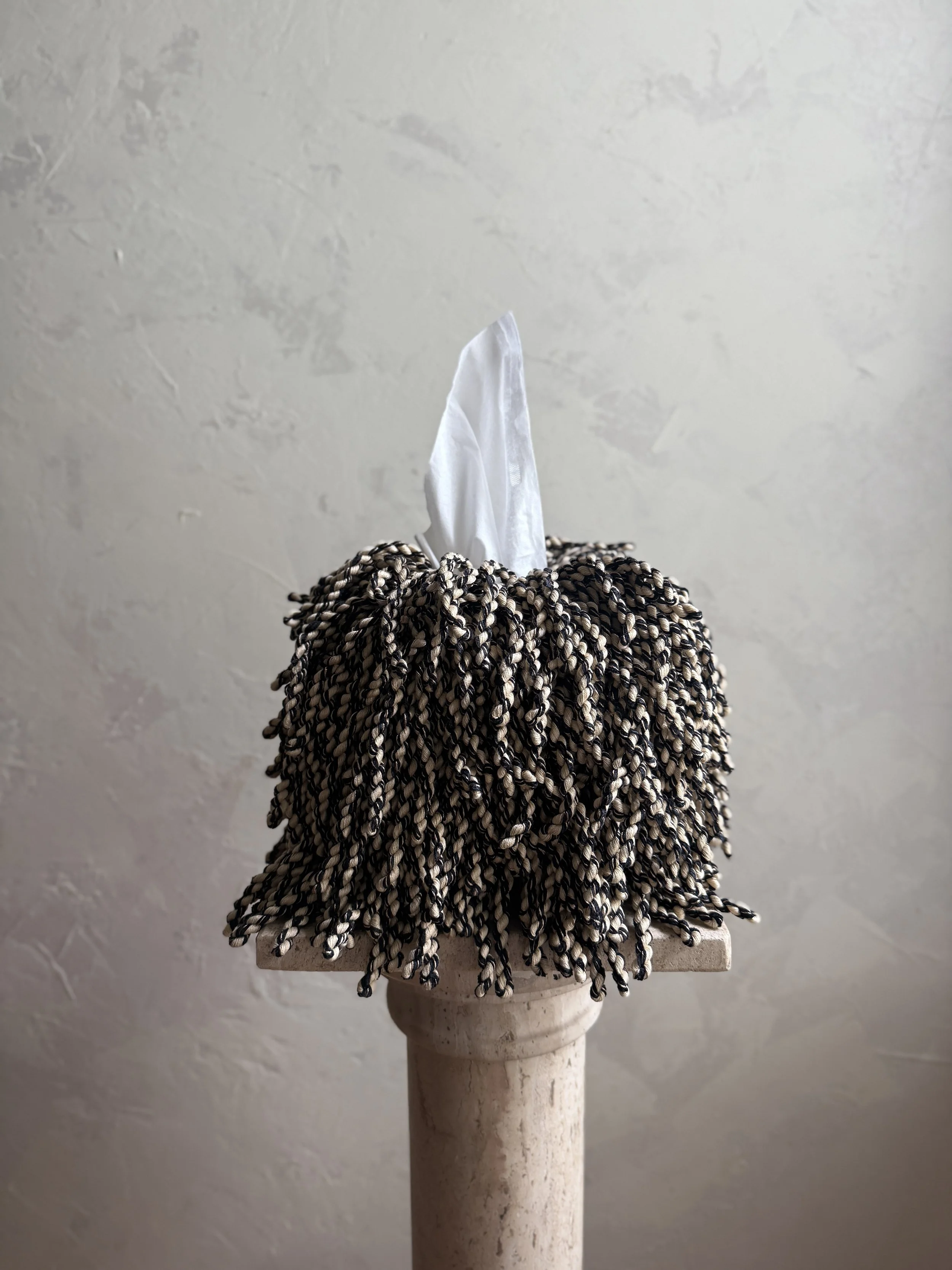 Fringe tissue box cover in oat milk and char black tones — hand-wrapped, sculptural home décor by Amber Renee Hansen.