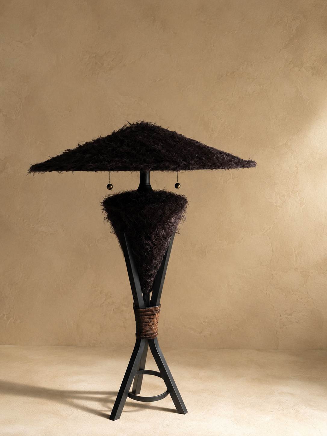 Triphora sculptural table lamp by Amber Renee Hansen with a deep brown faux fur amphora form and wide faux fur shade, black tripod frame, and wrapped cord detail.