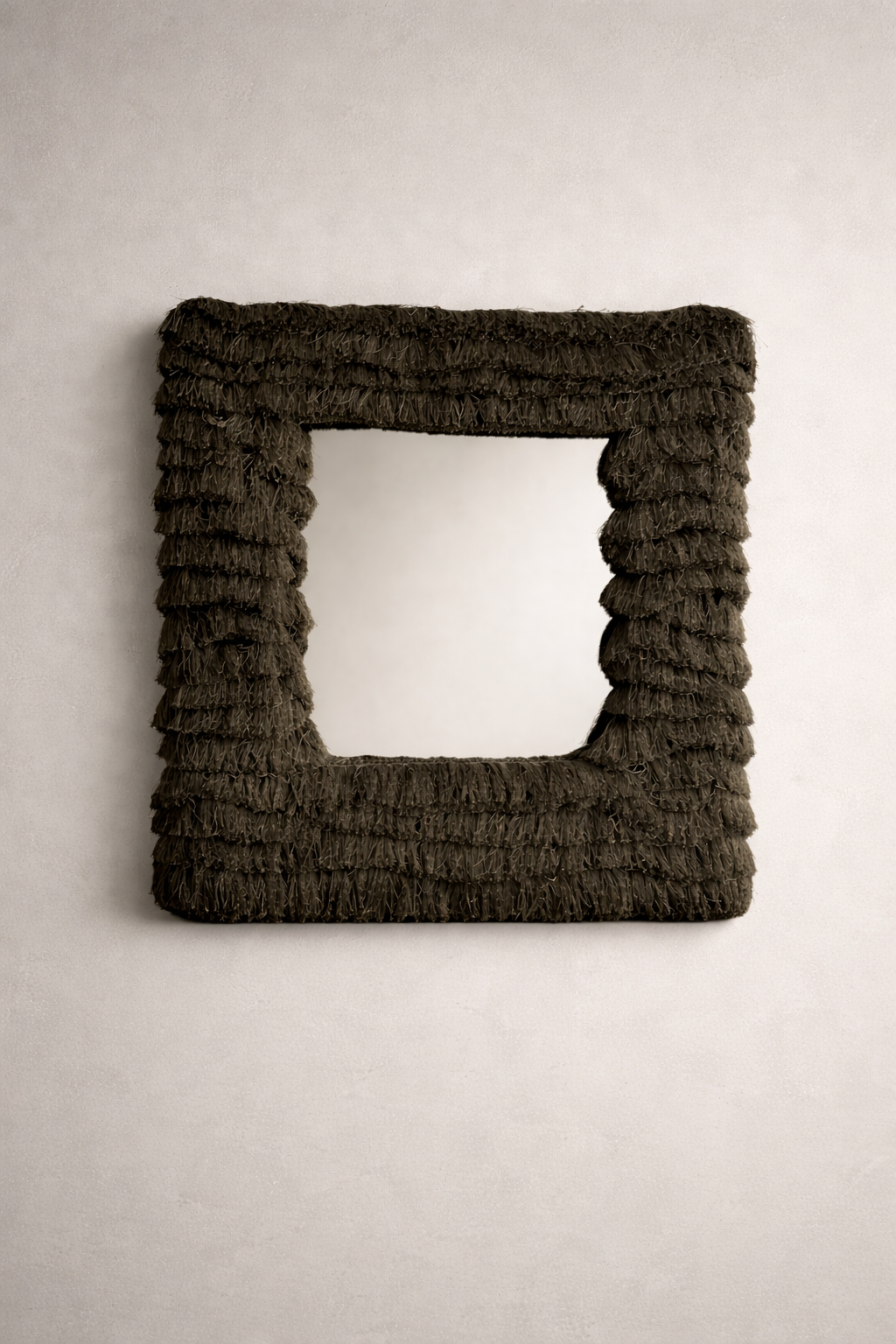 Layered olive fringe square wall mirror with sculptural texture photographed in a neutral studio setting