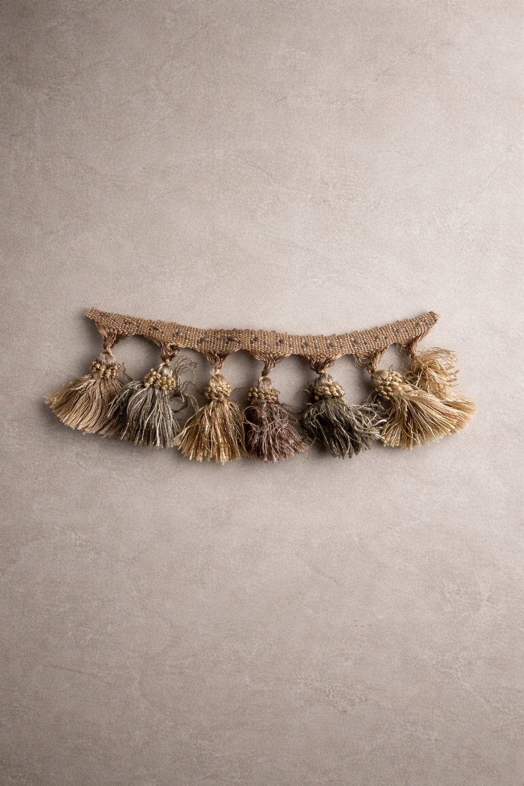 Rosé dune tassel tissue box cover with layered blush, taupe, and golden sand tones in an overhead view