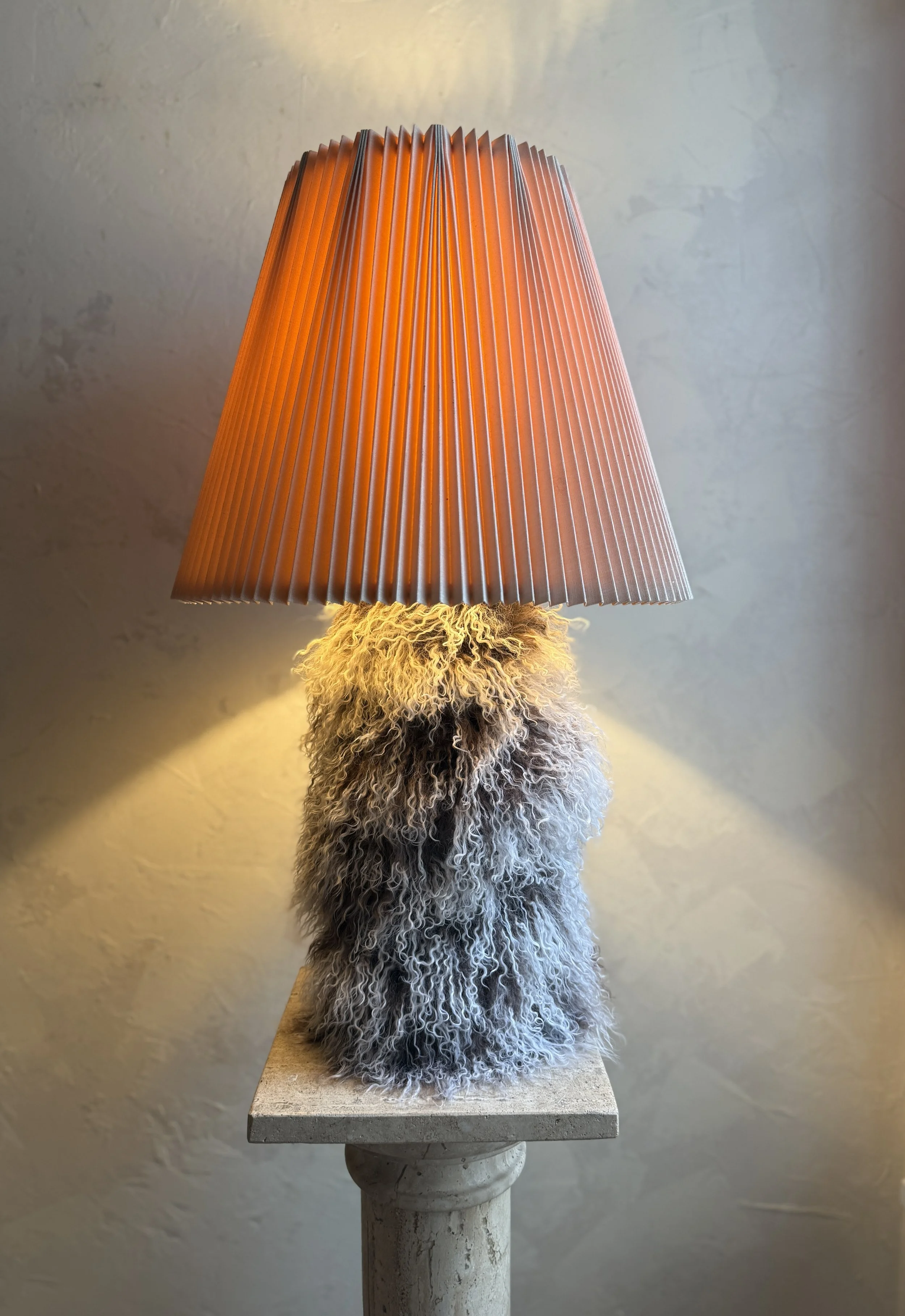 Two-tone Mongolian sheepskin table lamp with pleated shade on display.