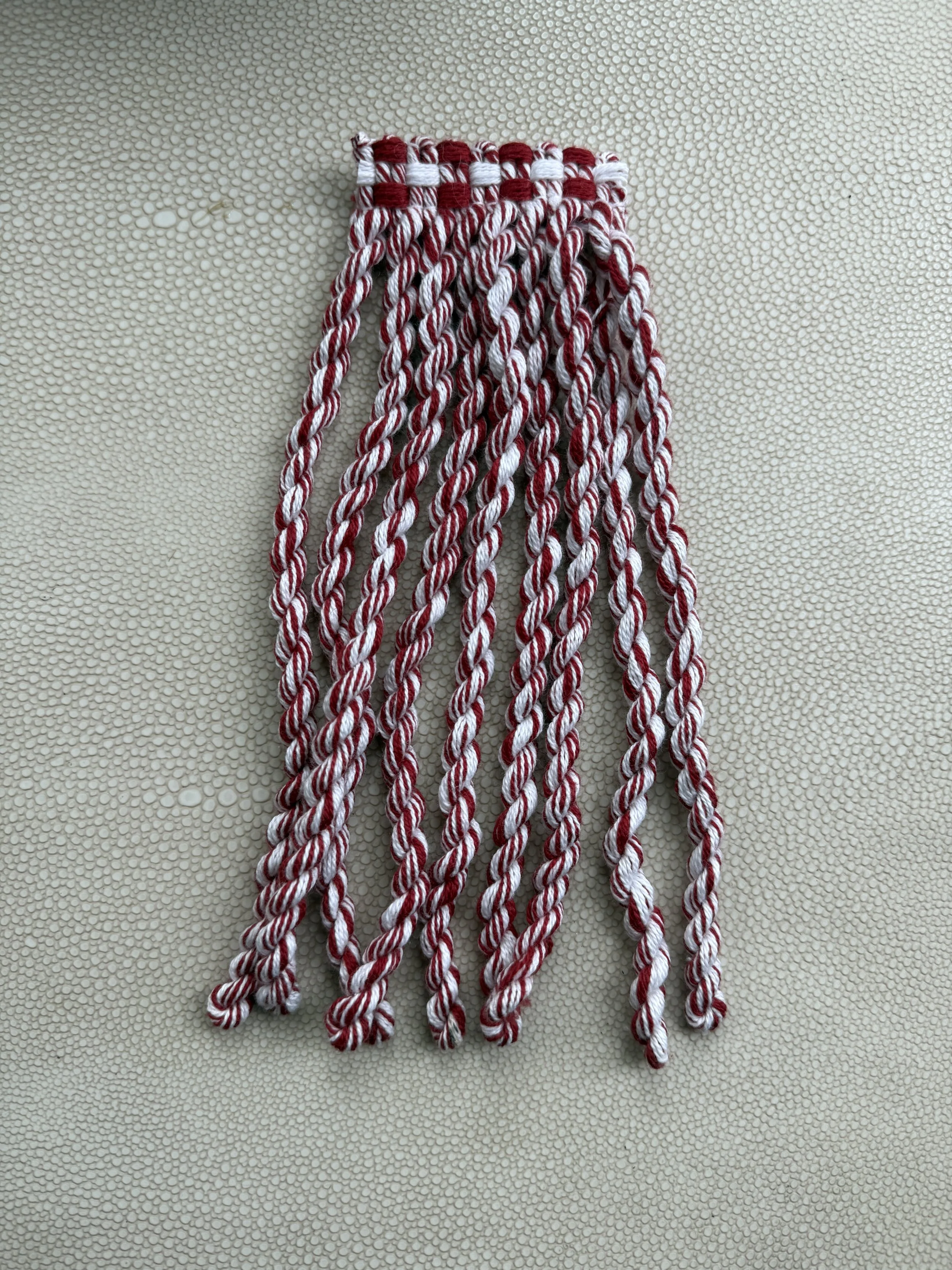 Handmade red and white fringe tissue box cover with soft cane-twist texture.