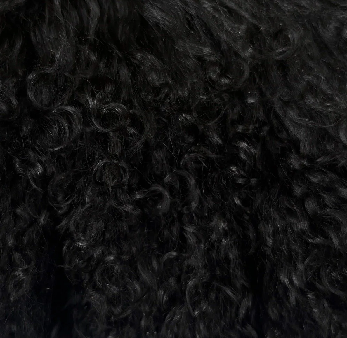 Wing Span Mongolian Lamb Bench in Ink Black featuring a dark espresso metal crossed frame, photographed in a quiet neutral setting