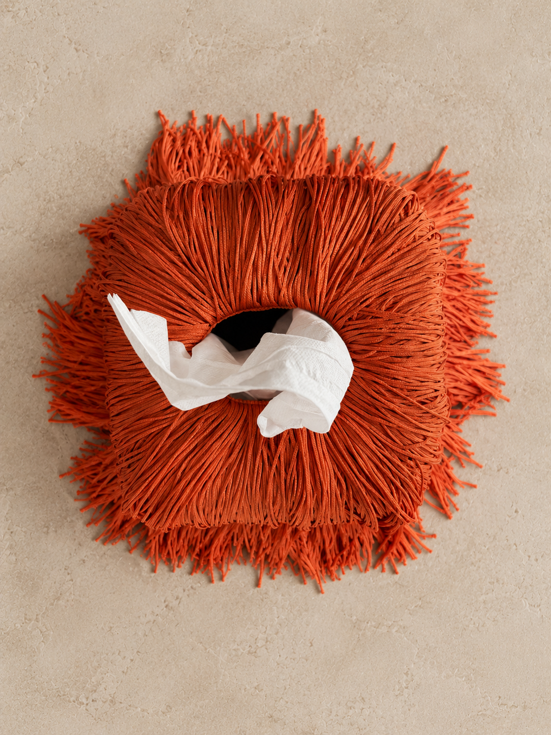 Oxide Orange Spill Edit Fringe Tissue Box Cover by Amber Renee Hansen, featuring cascading deep orange fringe with a subtle sheen and sculptural, floor-pooling movement.