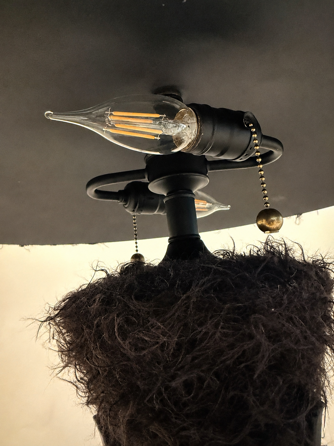 Triphora sculptural table lamp by Amber Renee Hansen with a deep brown faux fur amphora form and wide faux fur shade, black tripod frame, and wrapped cord detail.