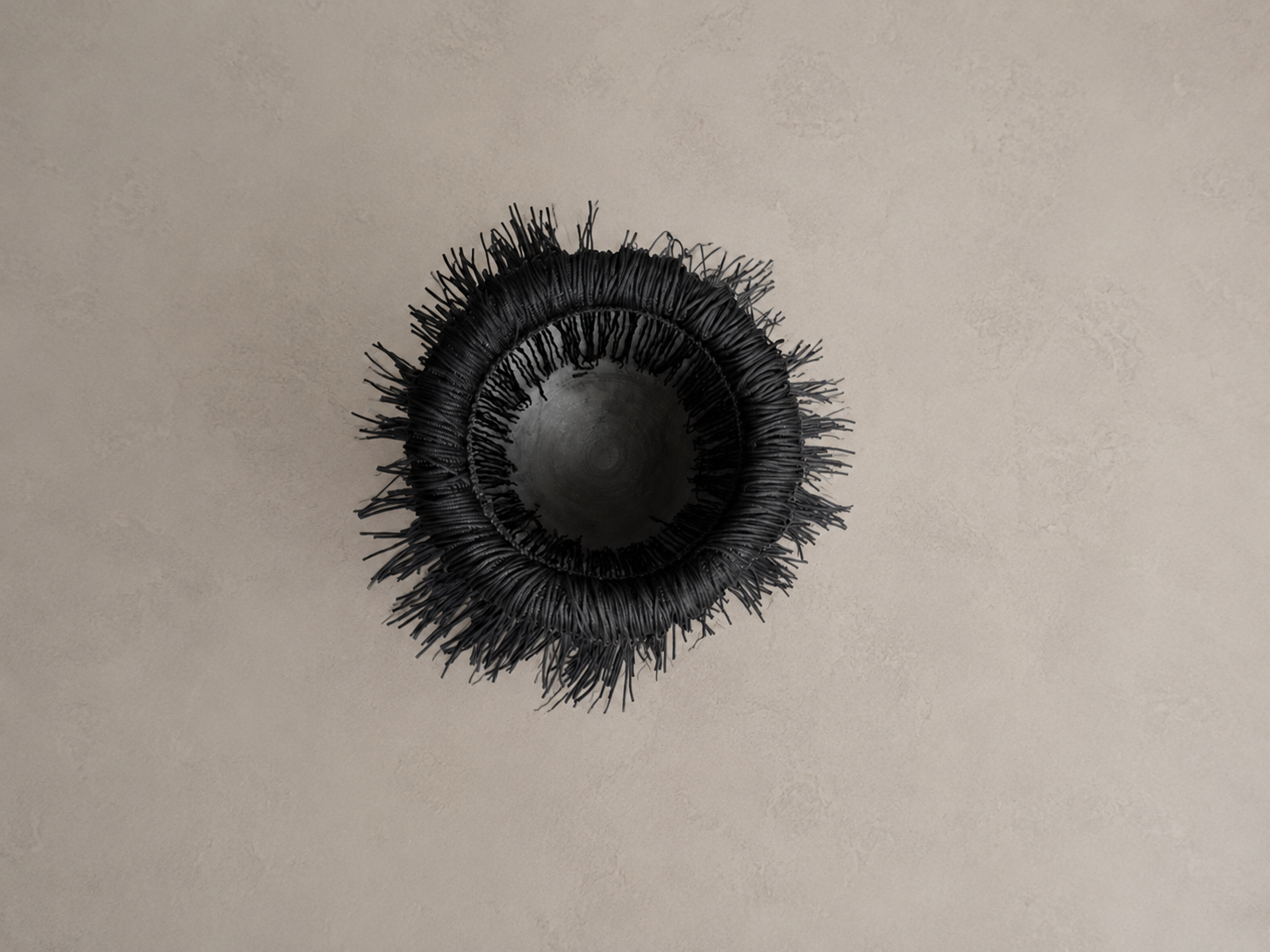 Overhead shot of the black fringe marble wine chiller, highlighting its circular design and cascading fringe from above.
