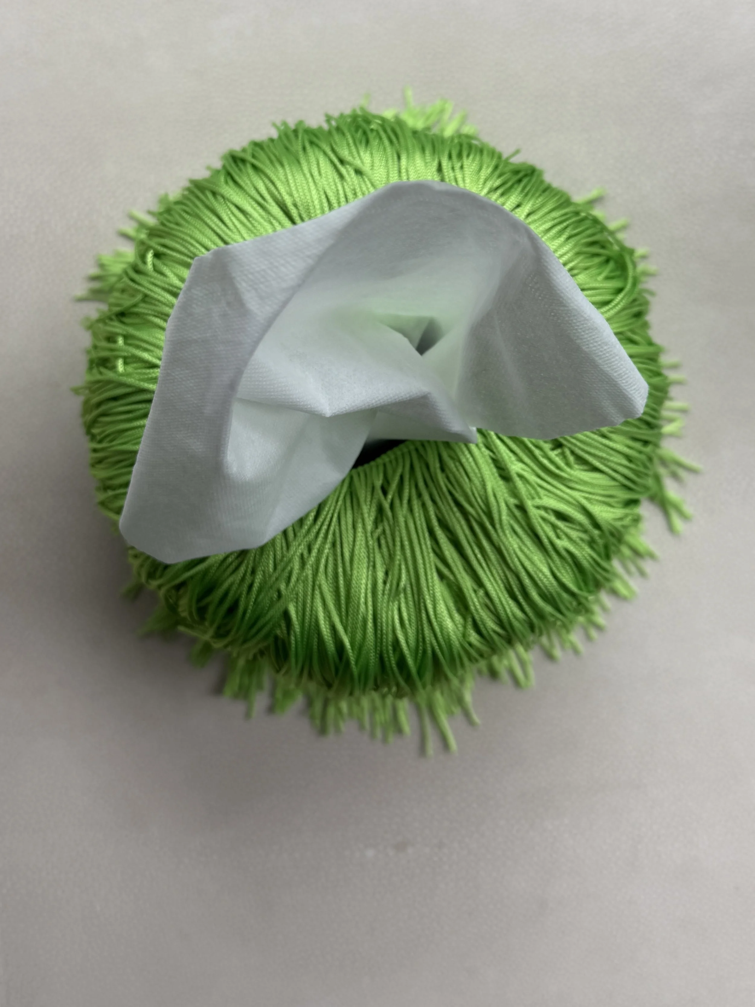 Soft Electric Green Fringe Tissue Box Cover — Spill Edit with round-form ceramic base wrapped in layered fringe, designed by Amber Renee Hansen.