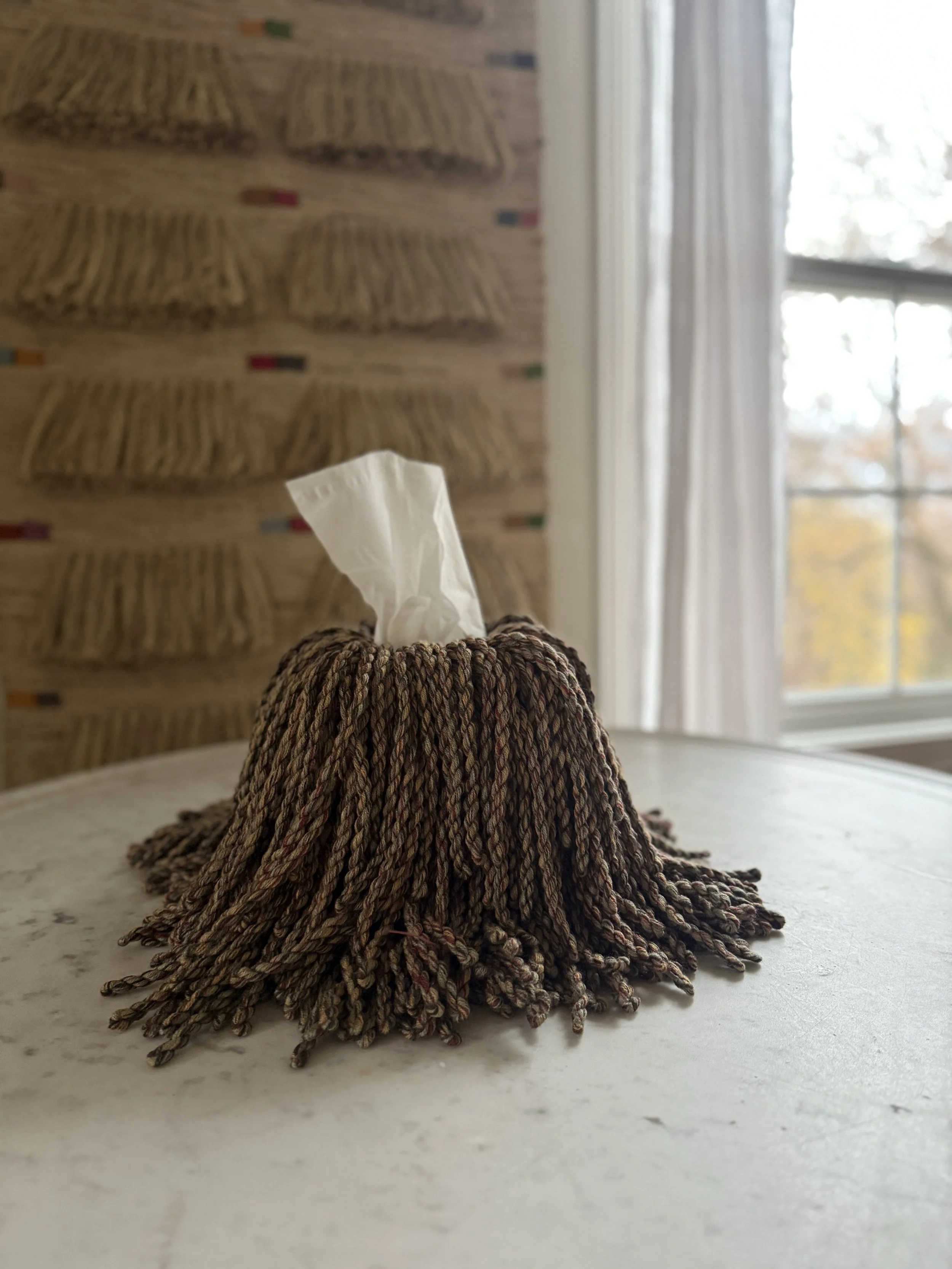 Meadow Knit Blend fringe tissue box cover wrapped in a green, merlot, sky-blue, and cream yarn blend — sculptural, textural, and handmade by Amber Renee Hansen.