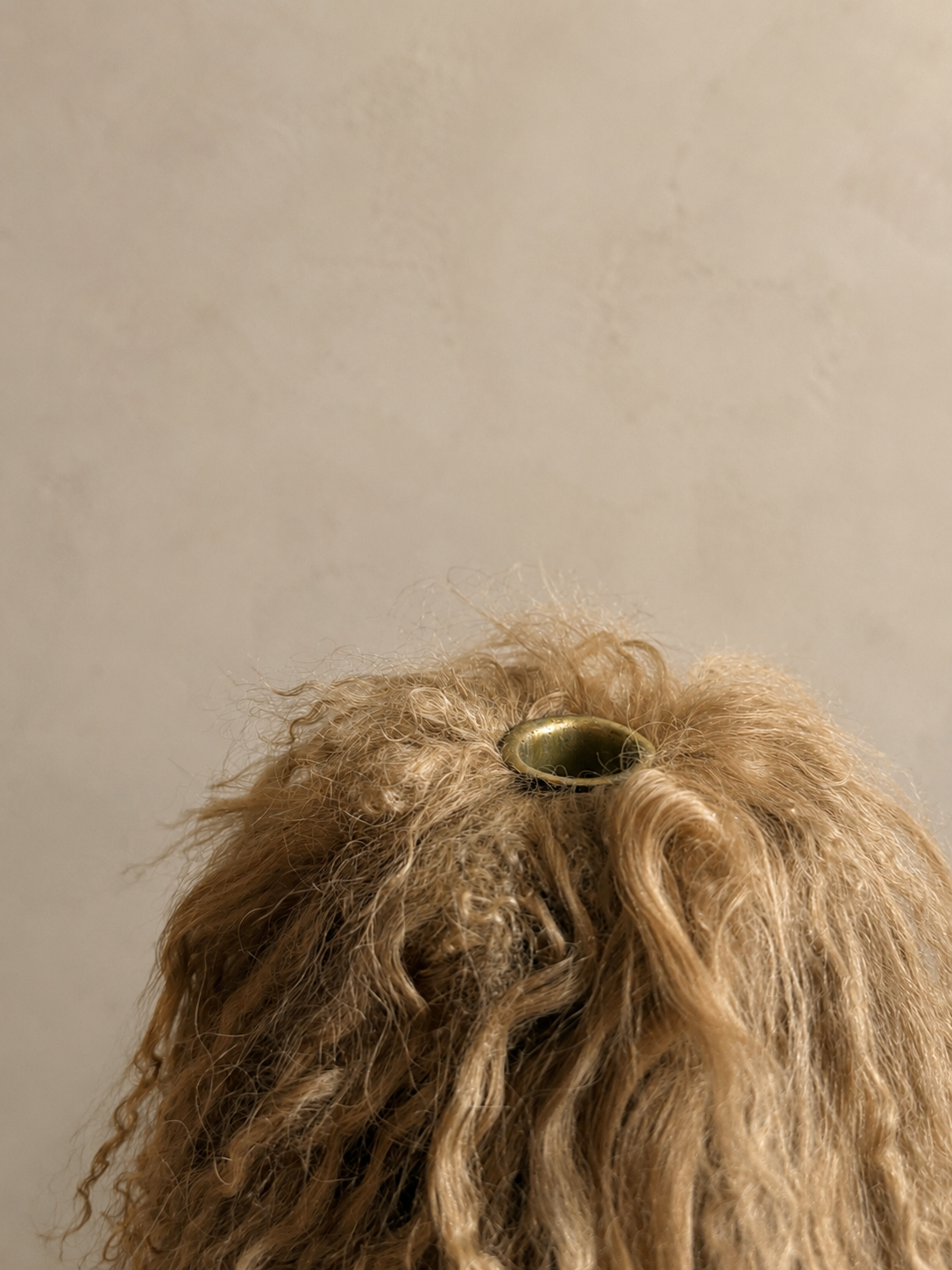Close-up detail of Miso Mongolian lamb taper holder showing natural lamb texture and gathered drape surrounding the candle base.
