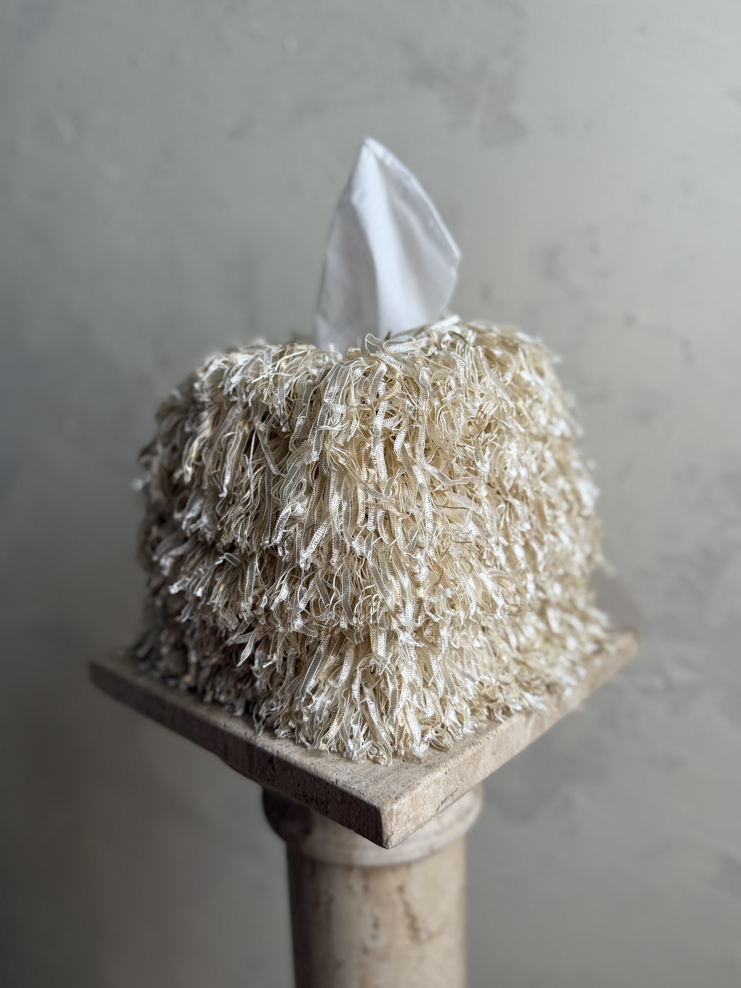 Side profile of Toasted Coconut Tangle Fringe Tissue Box Cover highlighting irregular fringe drape and depth
