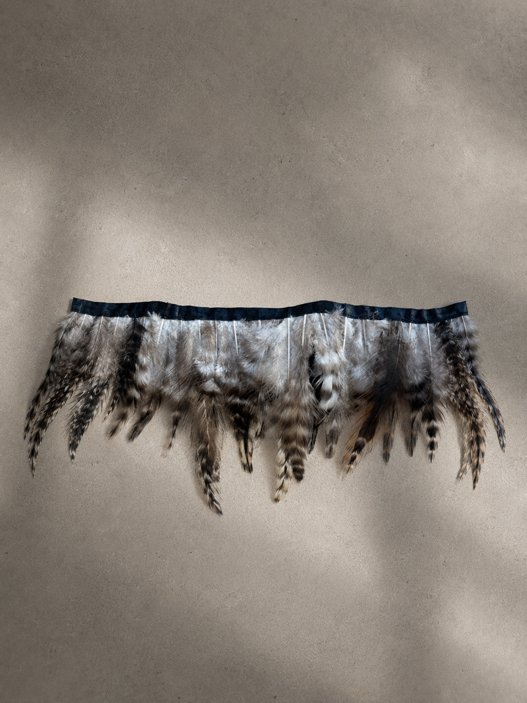 Tissue box cover made with rooster hackle feathers, inspired by the calm of fly fishing.